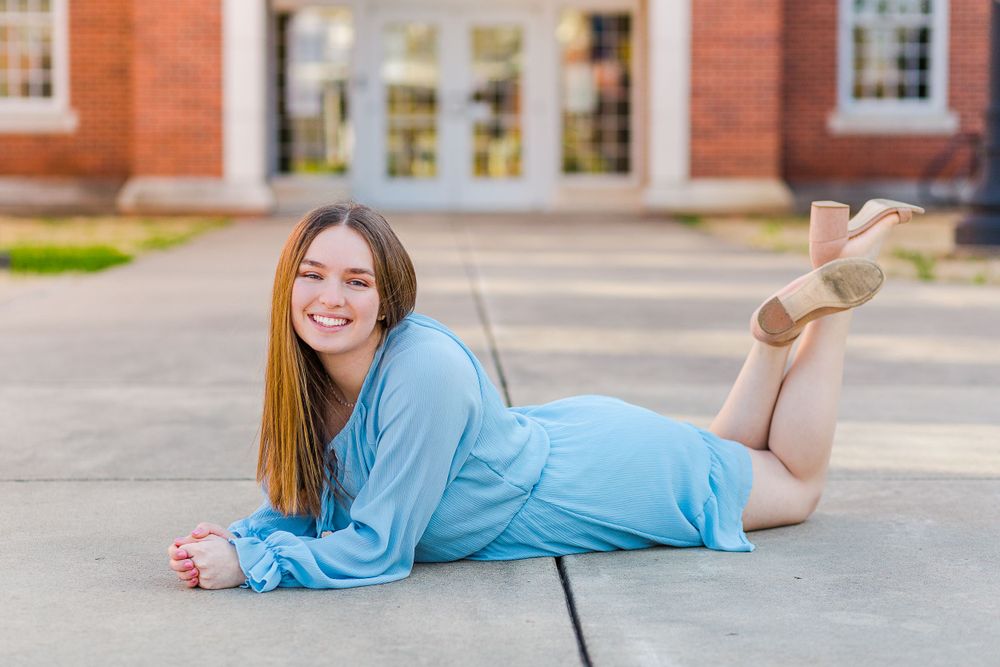A playful pose on campus sidewalk wearing a flowing light blue dress.