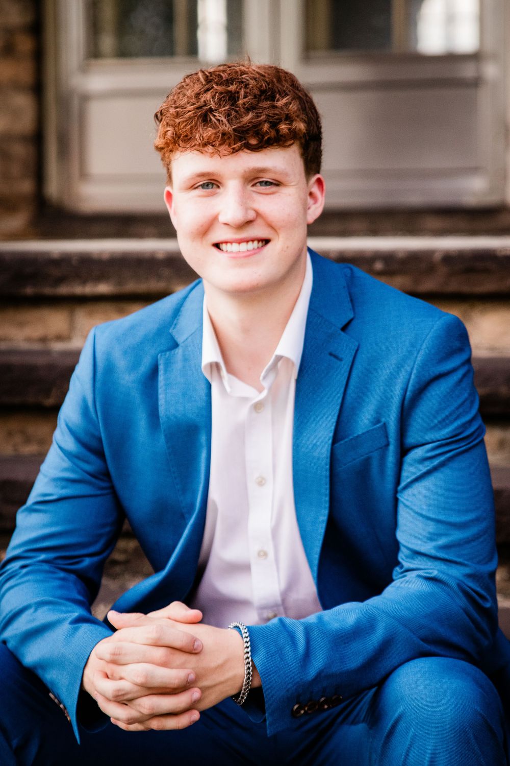Senior Boy Sitting on Steps Blue Suit Red Curly Hair