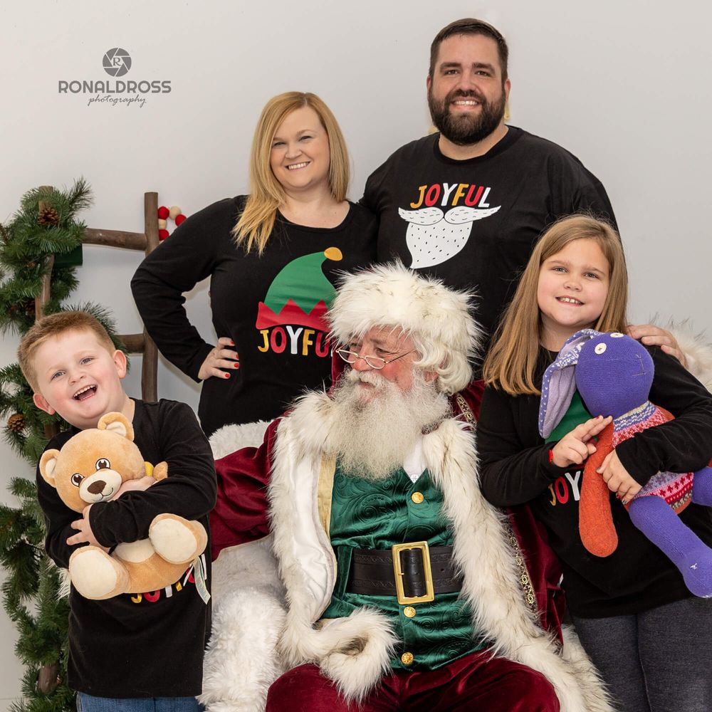 Family holiday portrait session with Santa Claus and festive decorations.