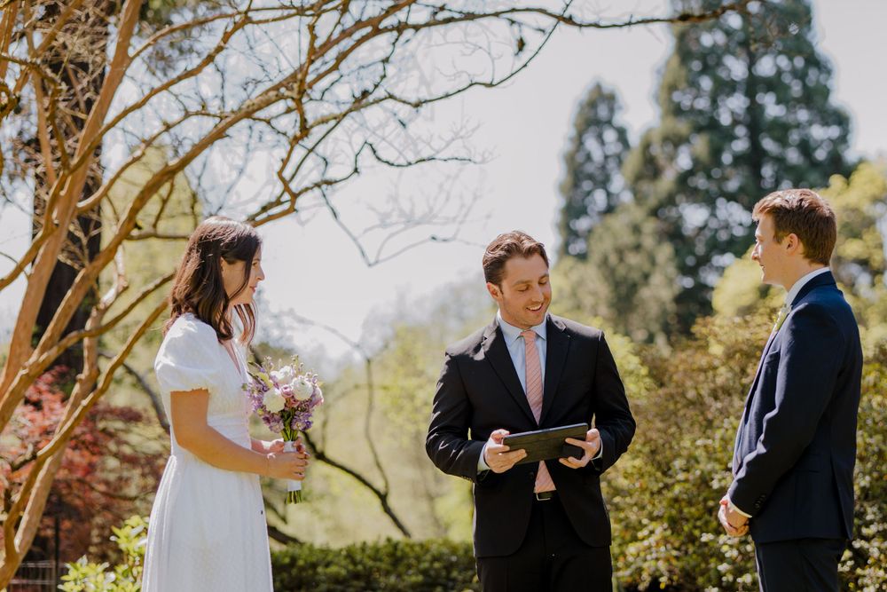 Bride and groom standing with officiant during ceremony