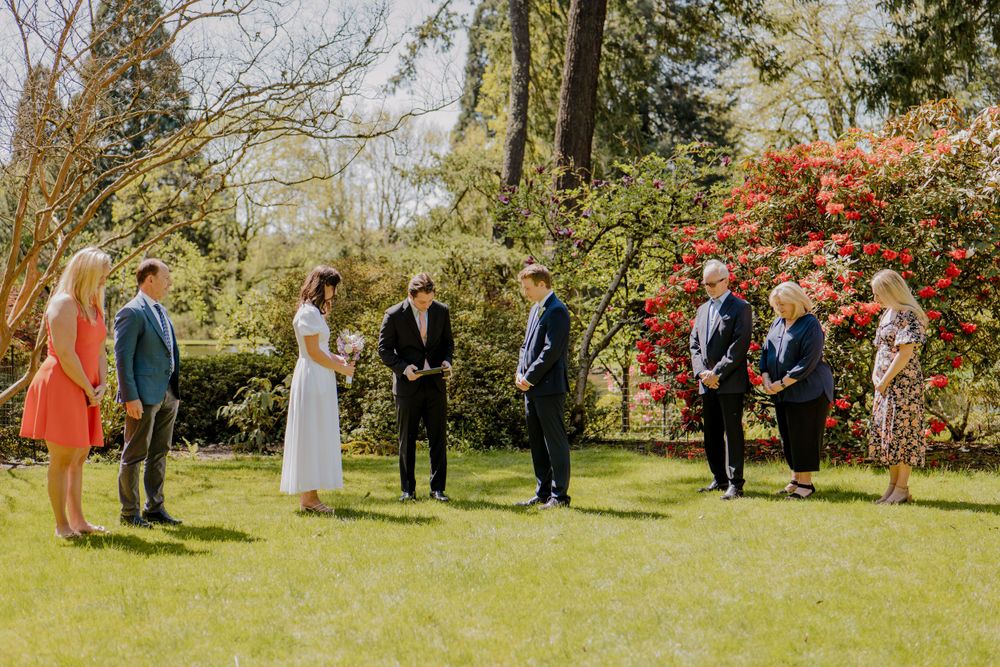 Wedding party standing and watching Bride and groom during ceremony