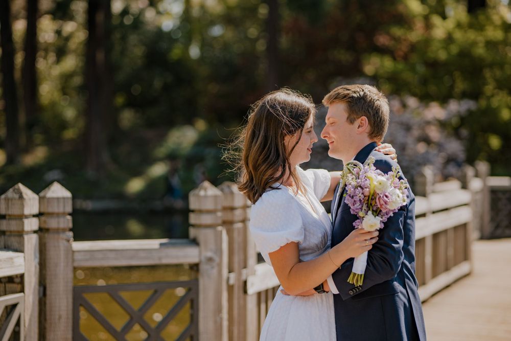 Bride and groom close dancing on wooden bridge