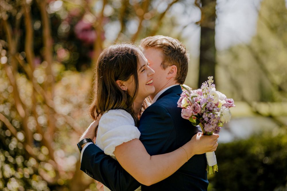 Bride and groom smiling and hugging after first kiss