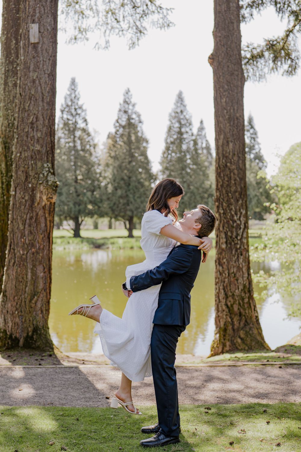 Bride kicking her leg back while groom lifts her in the air