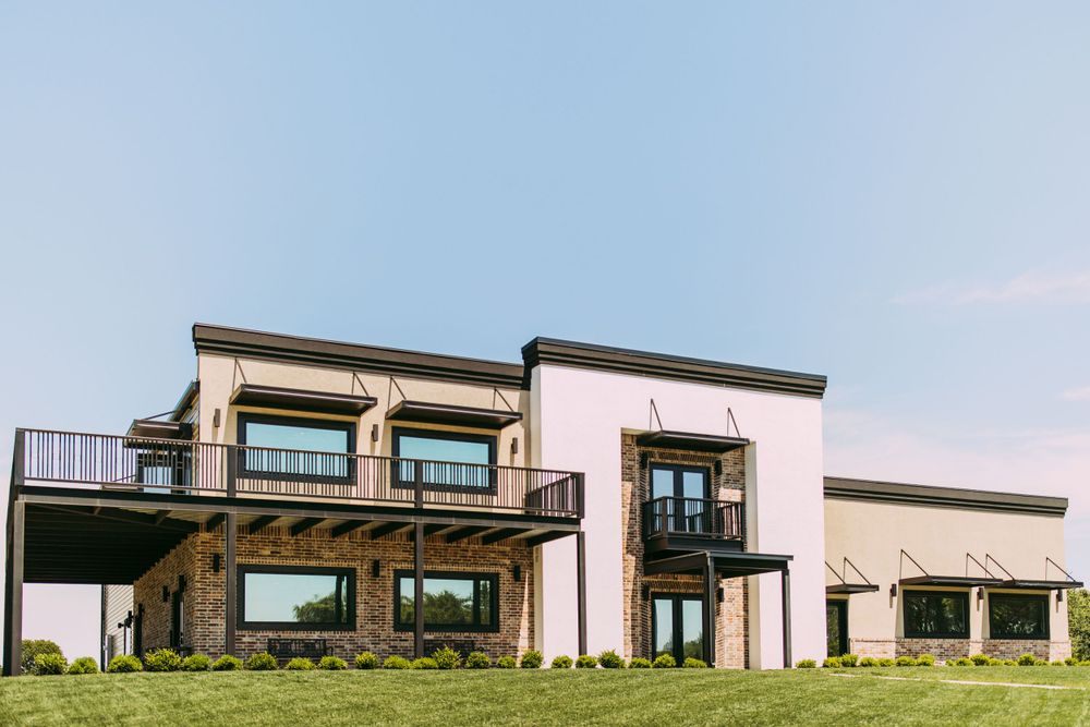 Modern architectural design featuring balconies and mixed materials on a spacious lawn.