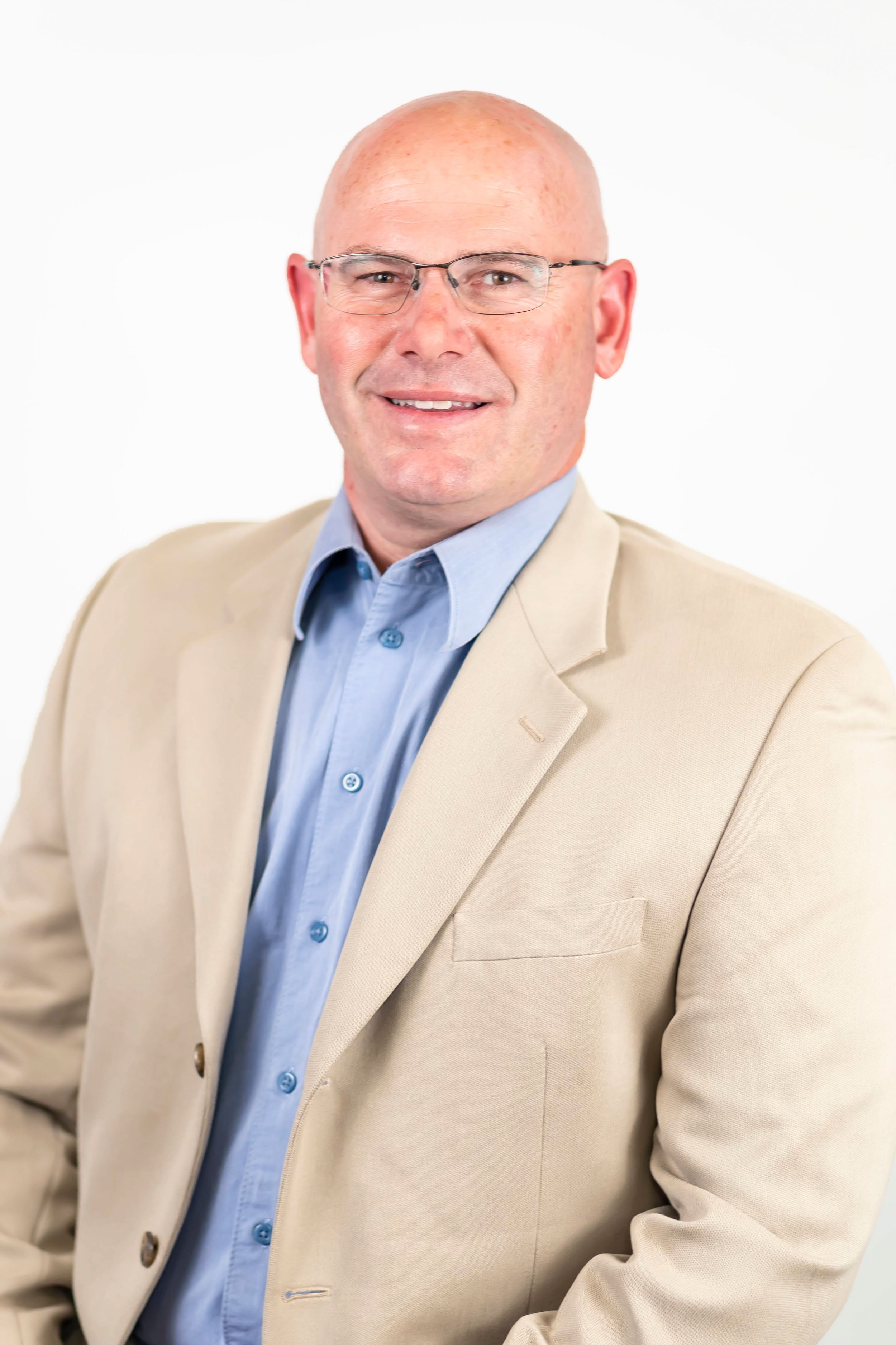 headshot of man in front of white wall