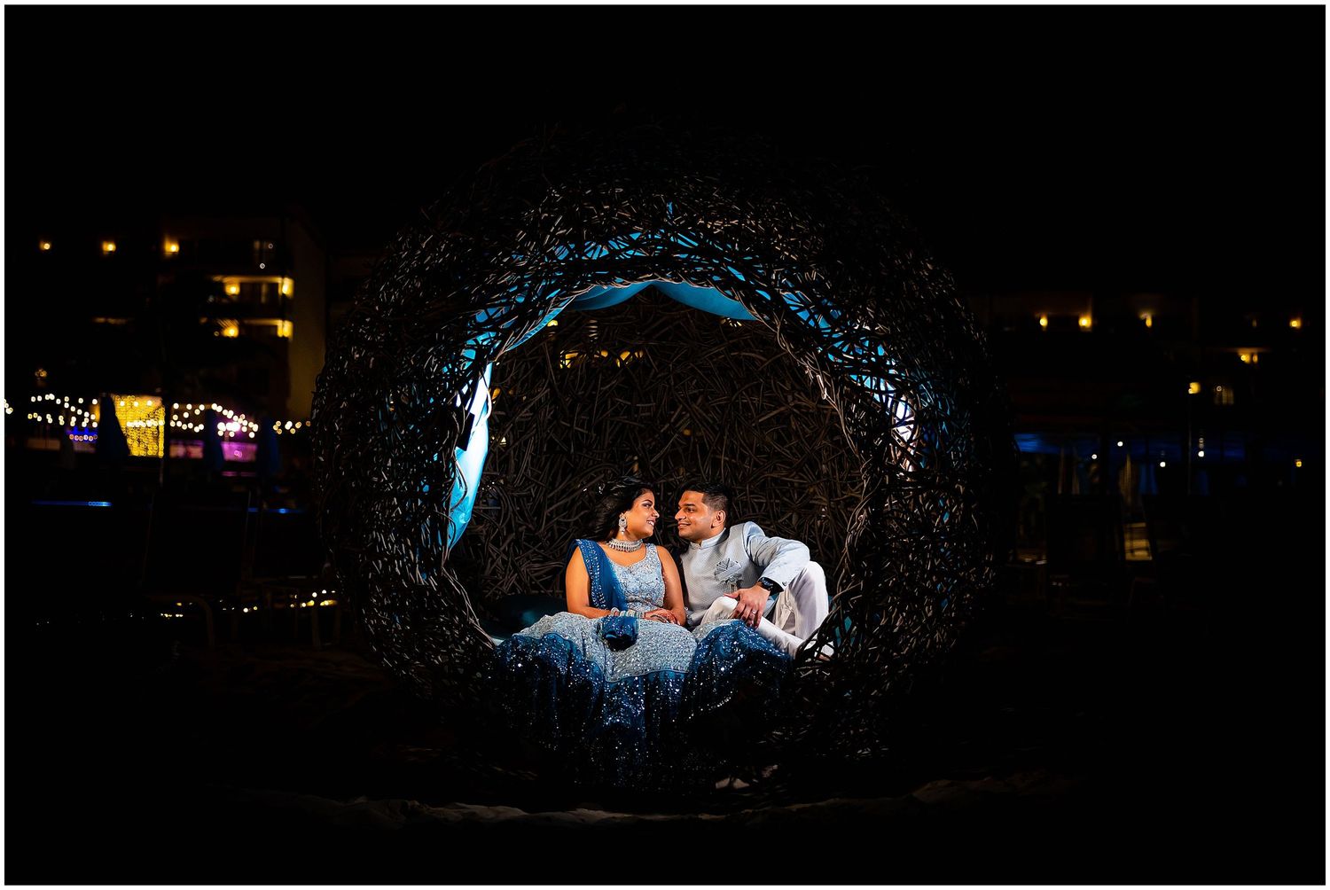 Artistic night portrait with blue lighting in a illuminated curved structure.