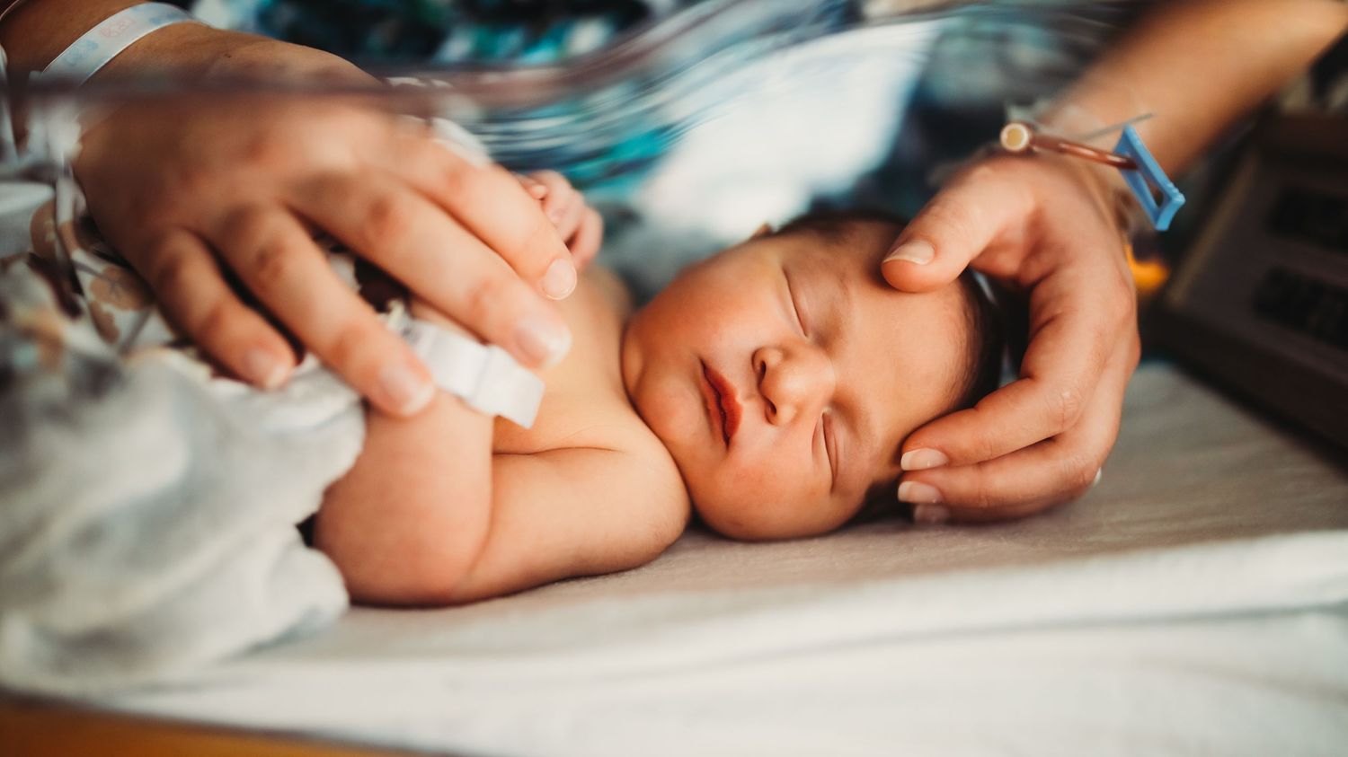 Gentle hands caring for a newborn baby during a medical examination.