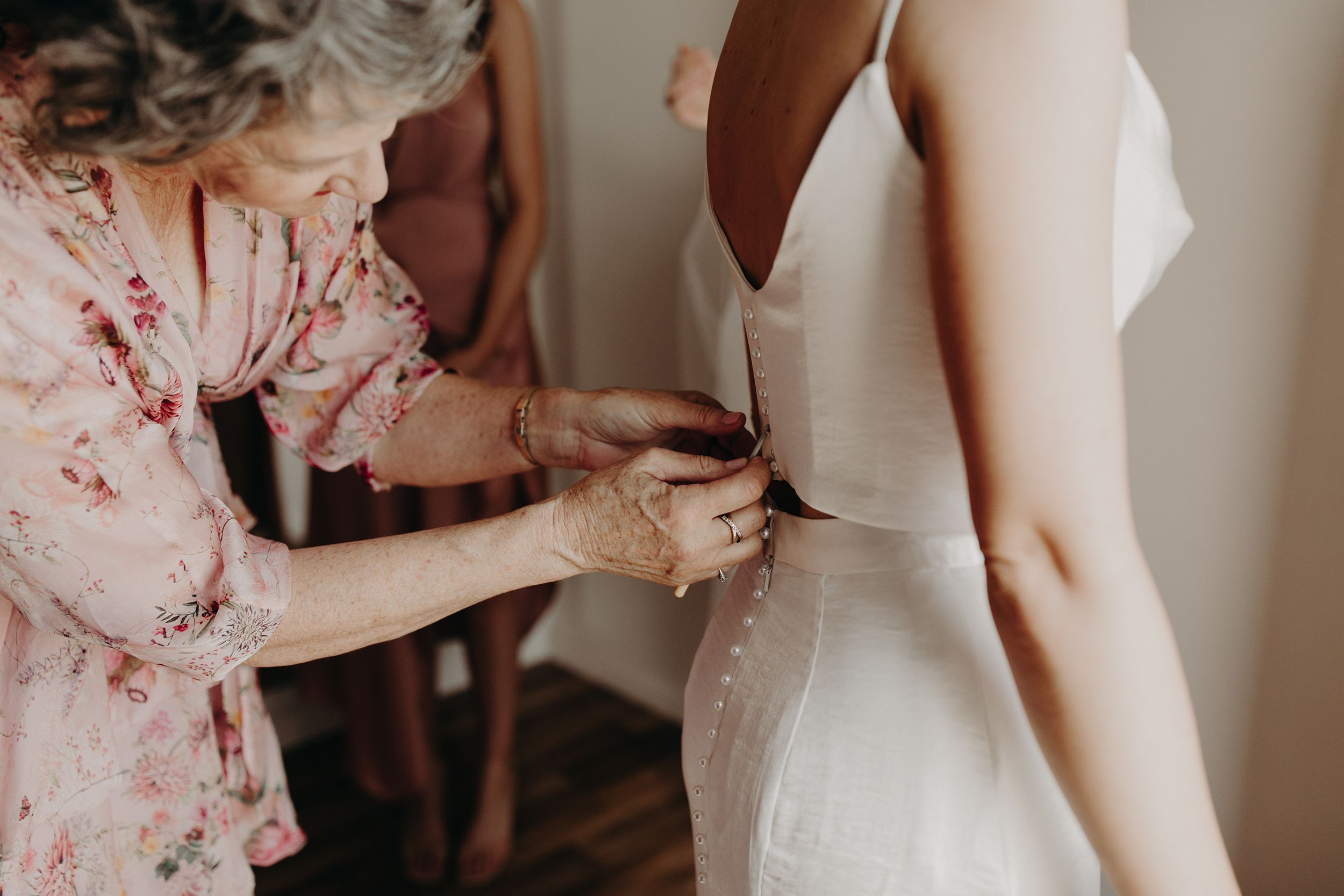 Wedding preparation scene with floral print robes and white dress details.