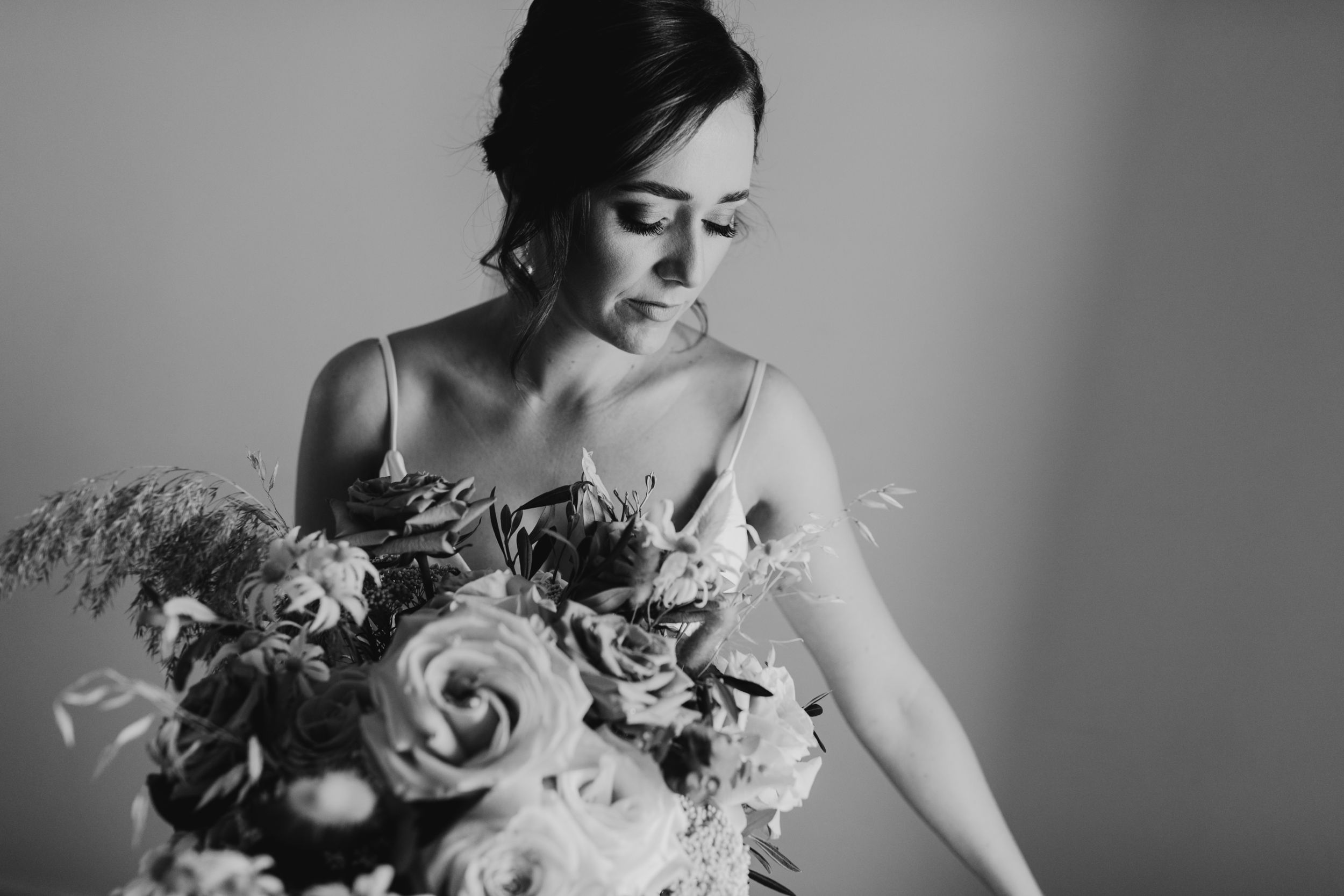 Black and white portrait with bridal bouquet and elegant wedding details.