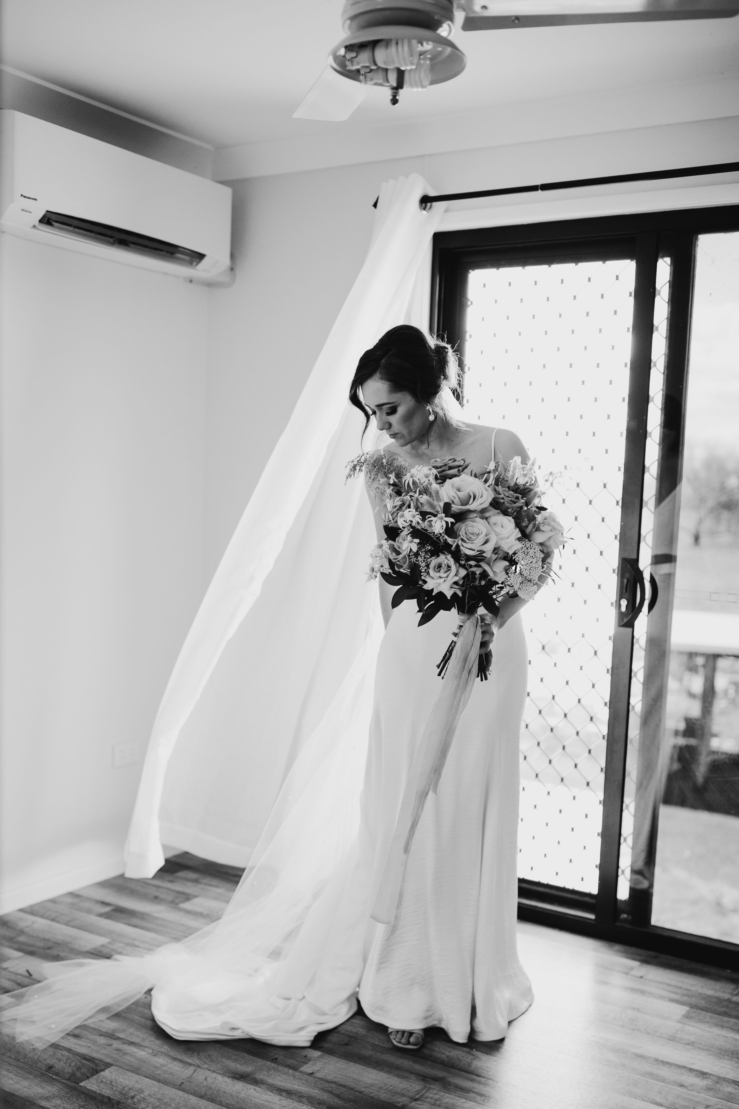 Black and white wedding photography sequence showing a flowing white dress in an elegant room.