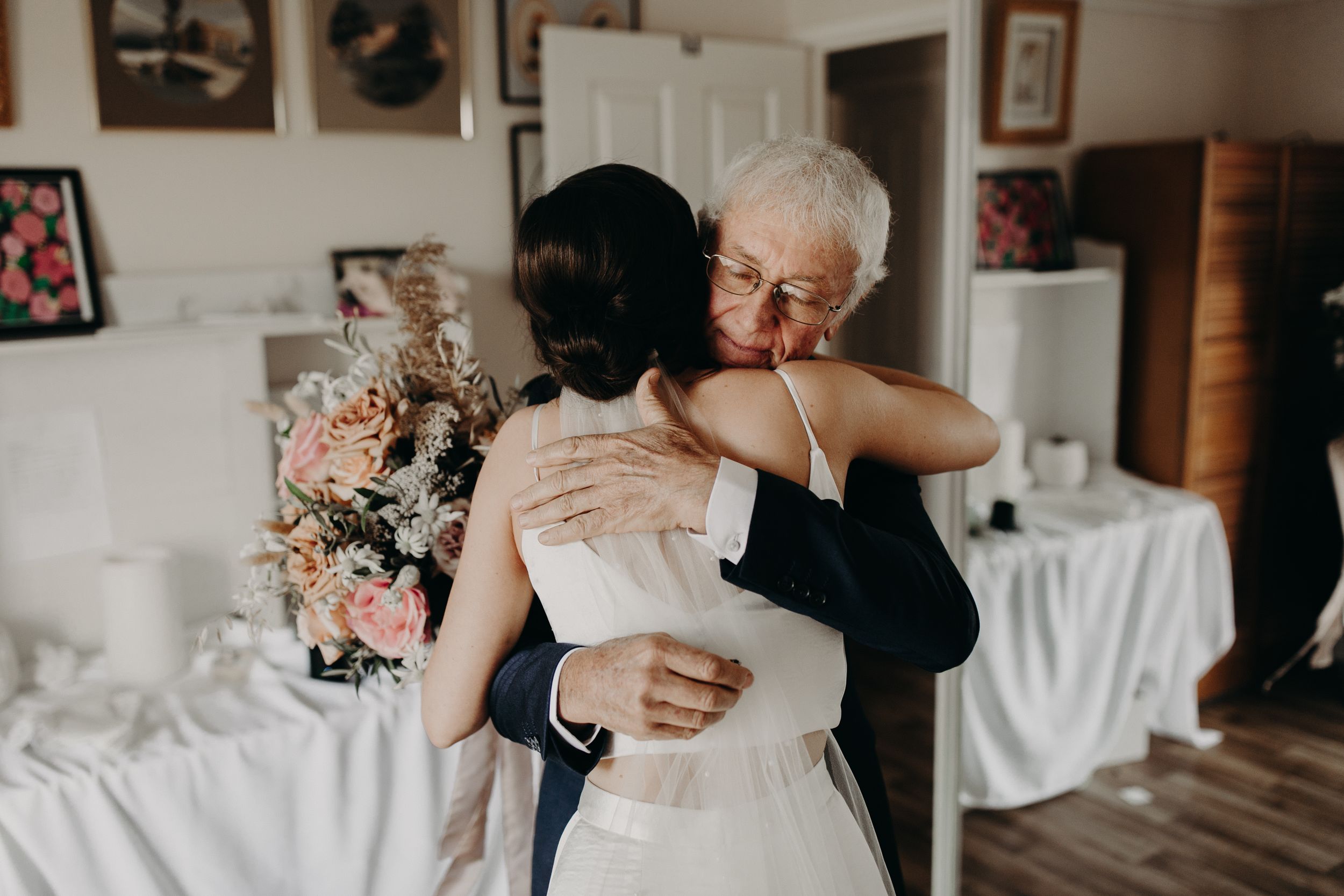 Intimate wedding moments captured in a light-filled room with white decor.
