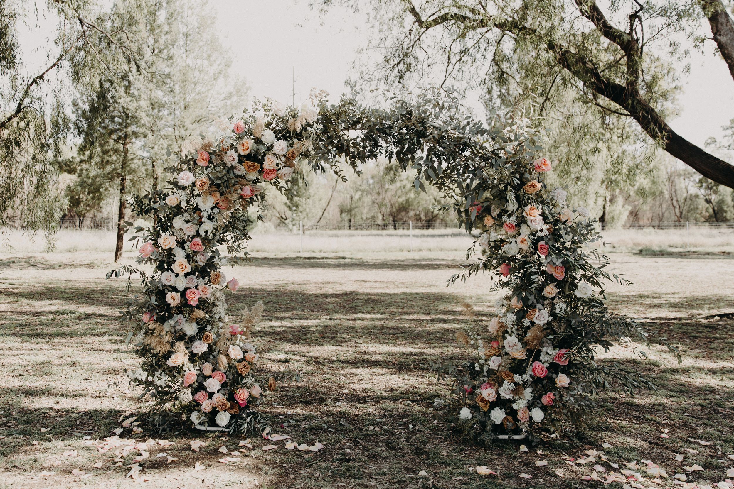 Wedding ceremony floral installation viewed from multiple angles in a natural outdoor setting.
