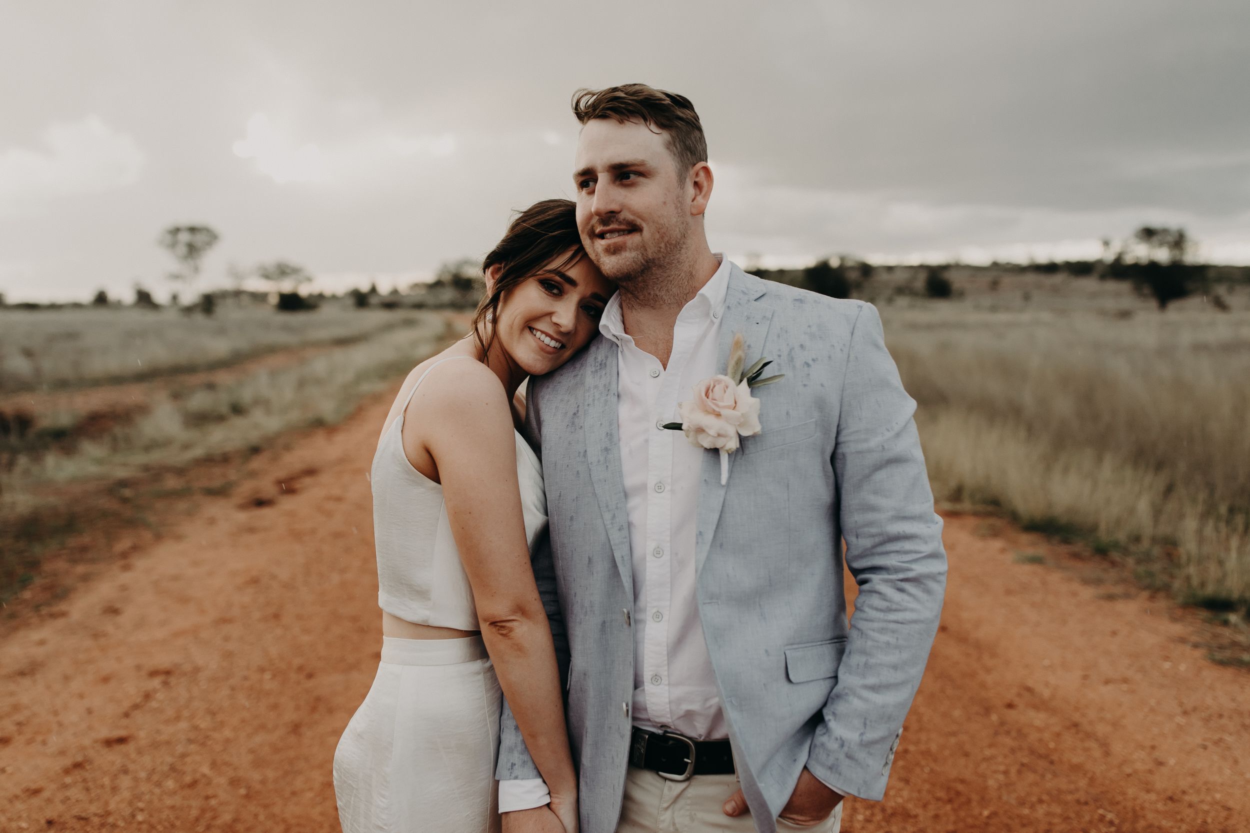 Romantic moment between newlyweds on a rustic outback road.
