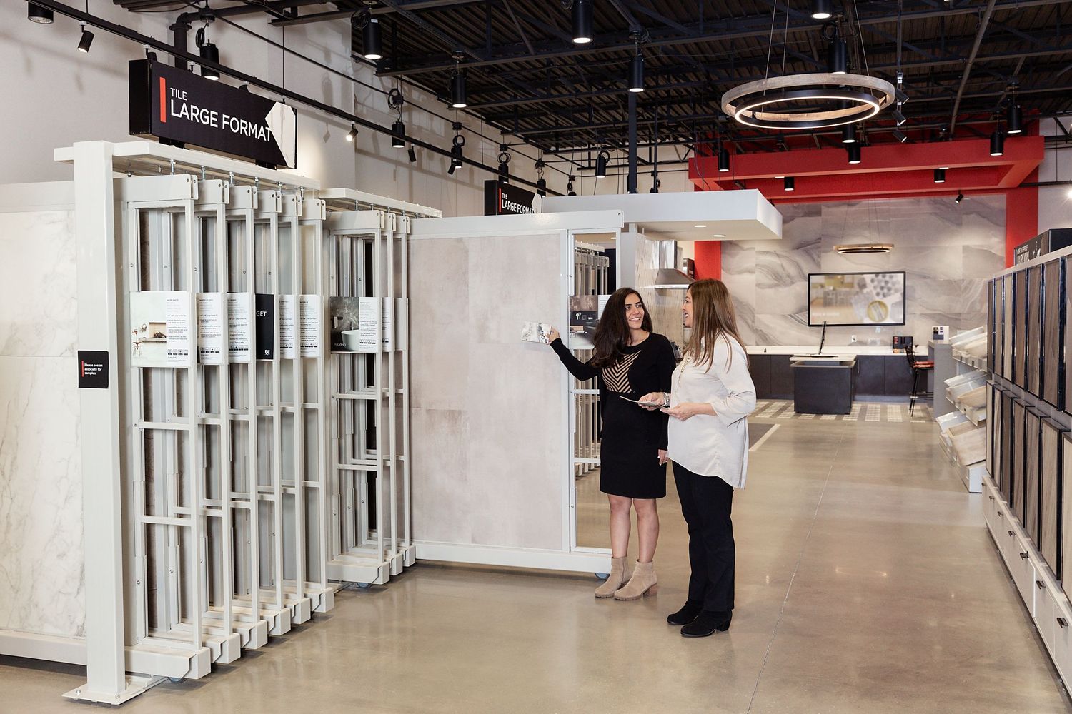 A sales rep at Floor & Decor shows off large format tile samples.