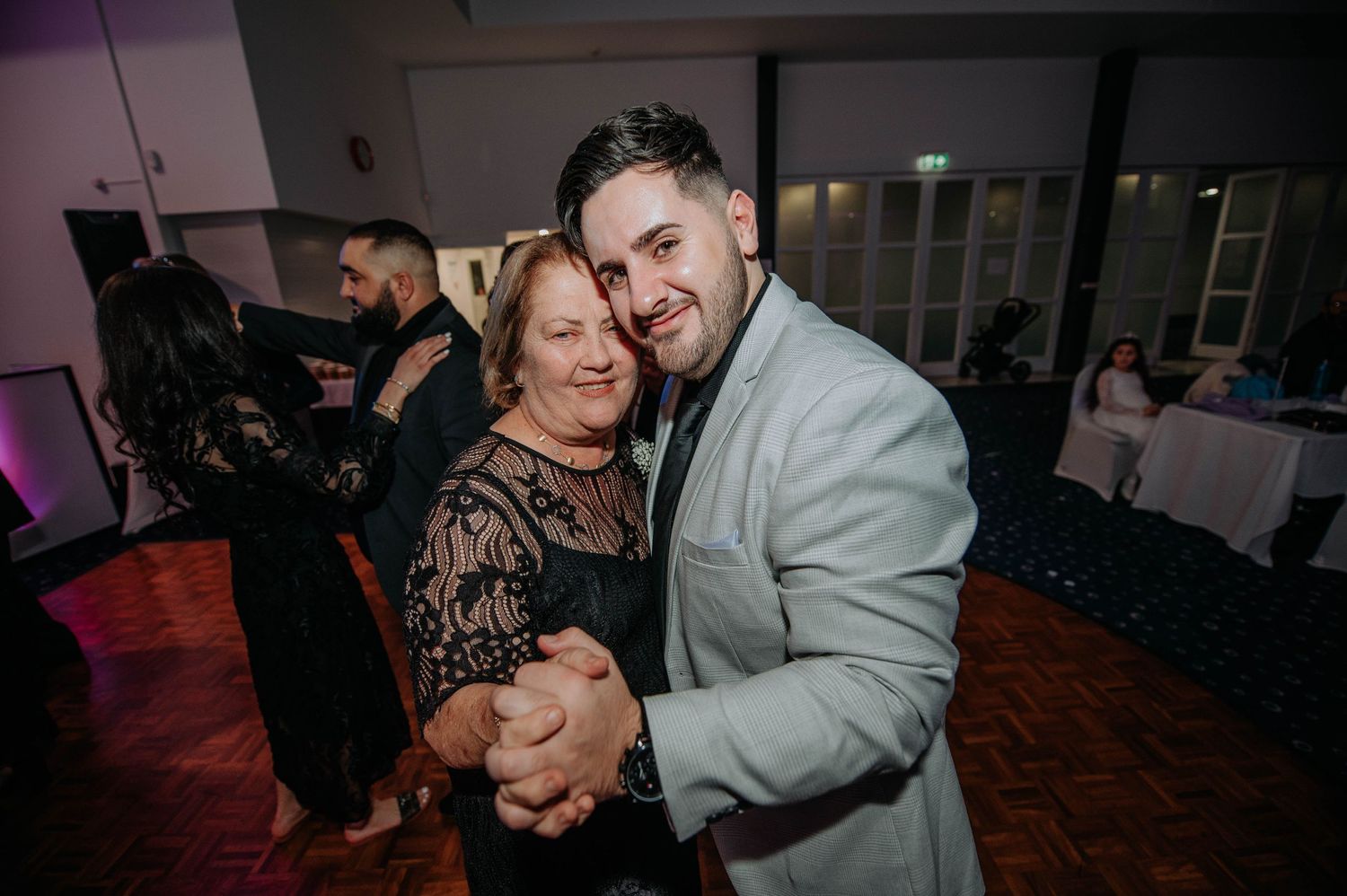 Sweet moment shared between mother and son dancing at wedding reception.