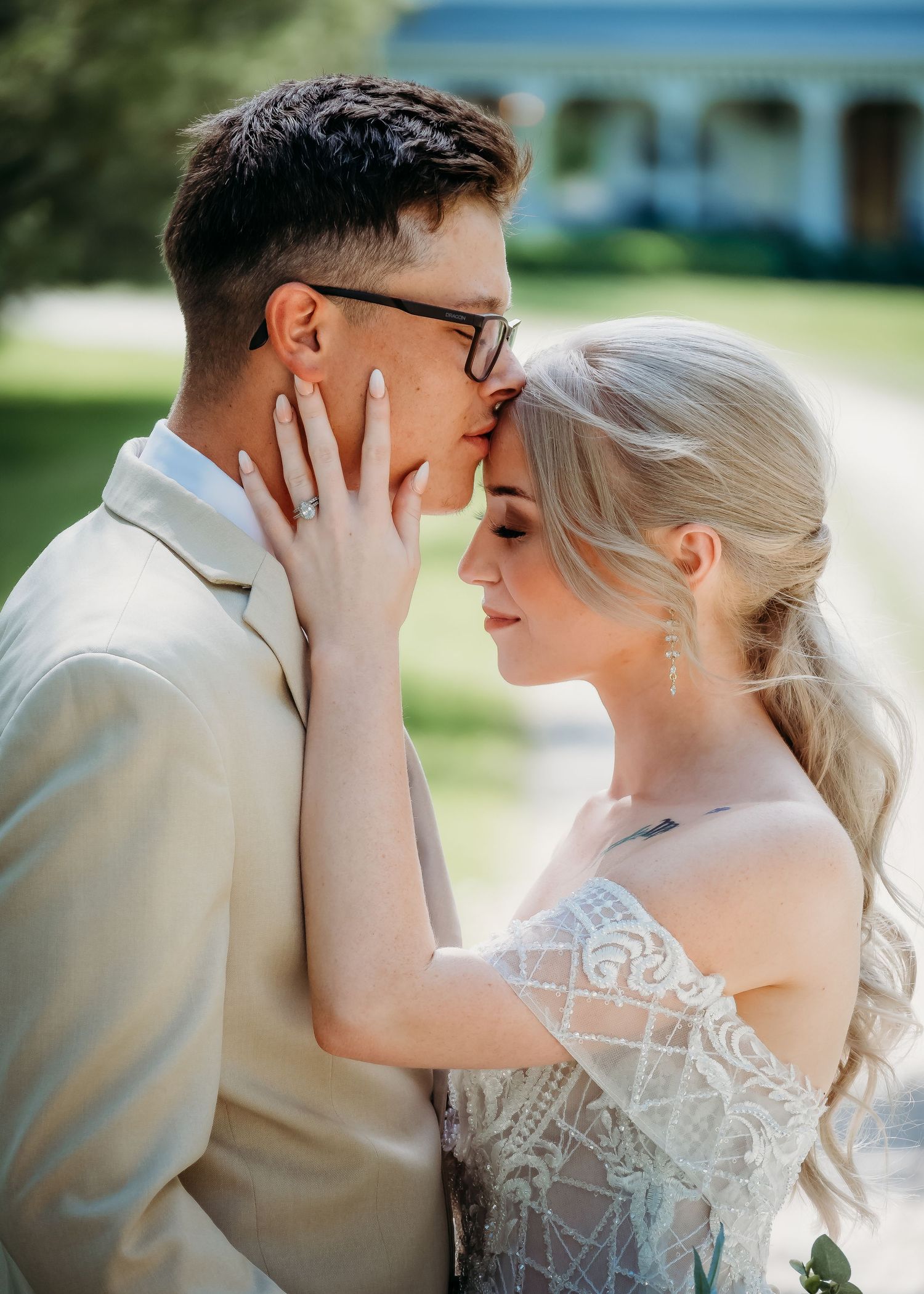 Groom kissing bride's forhead