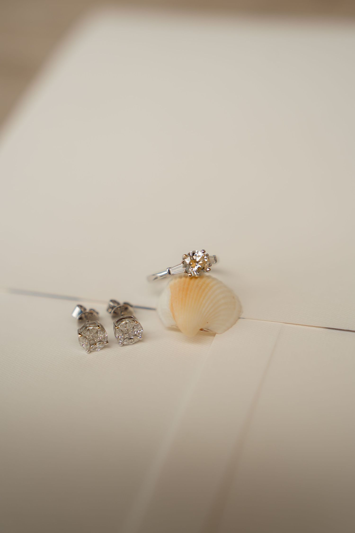 Delicate diamond engagement rings displayed on a soft white surface.