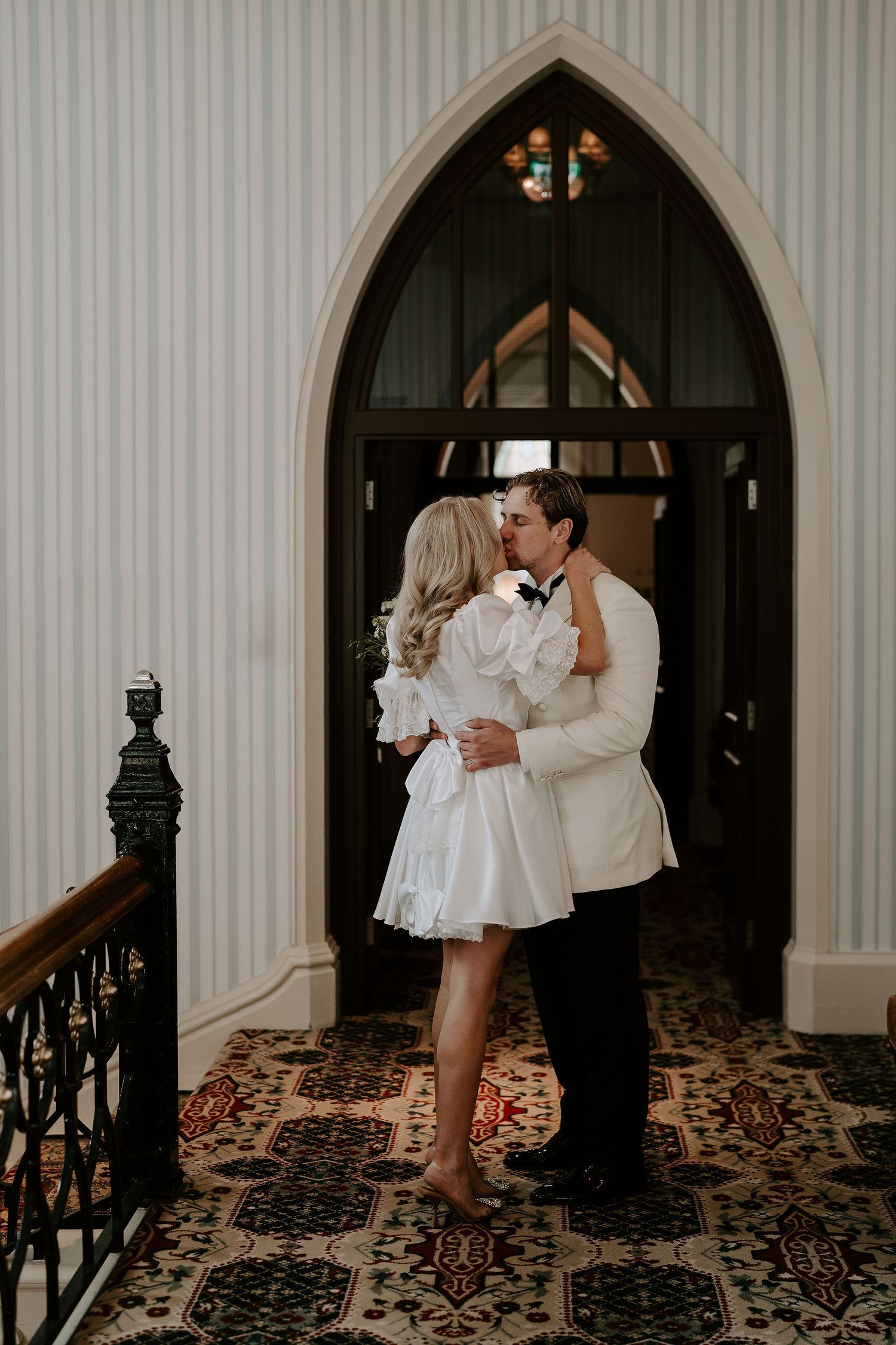 bride and groom kissing on the stairway at the Randolph hotel in oxford