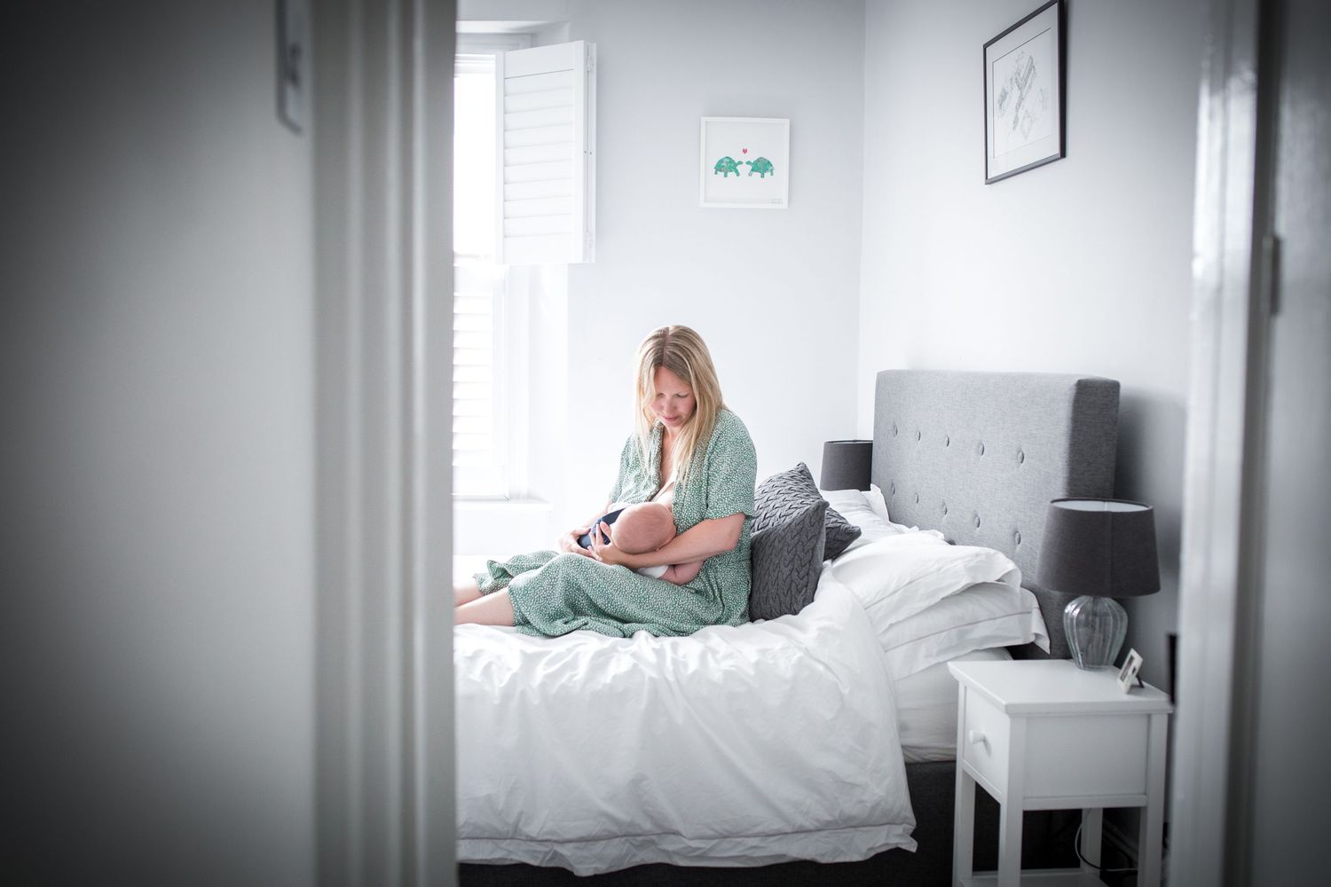 mother and new born baby breastfeeding in bed