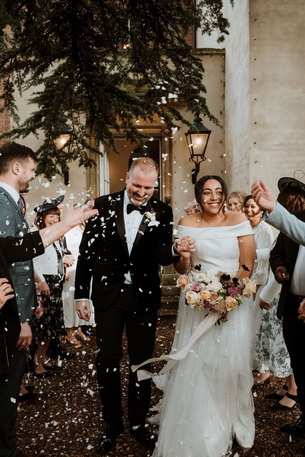 bride and groom in confetti line outside aswarby rectory