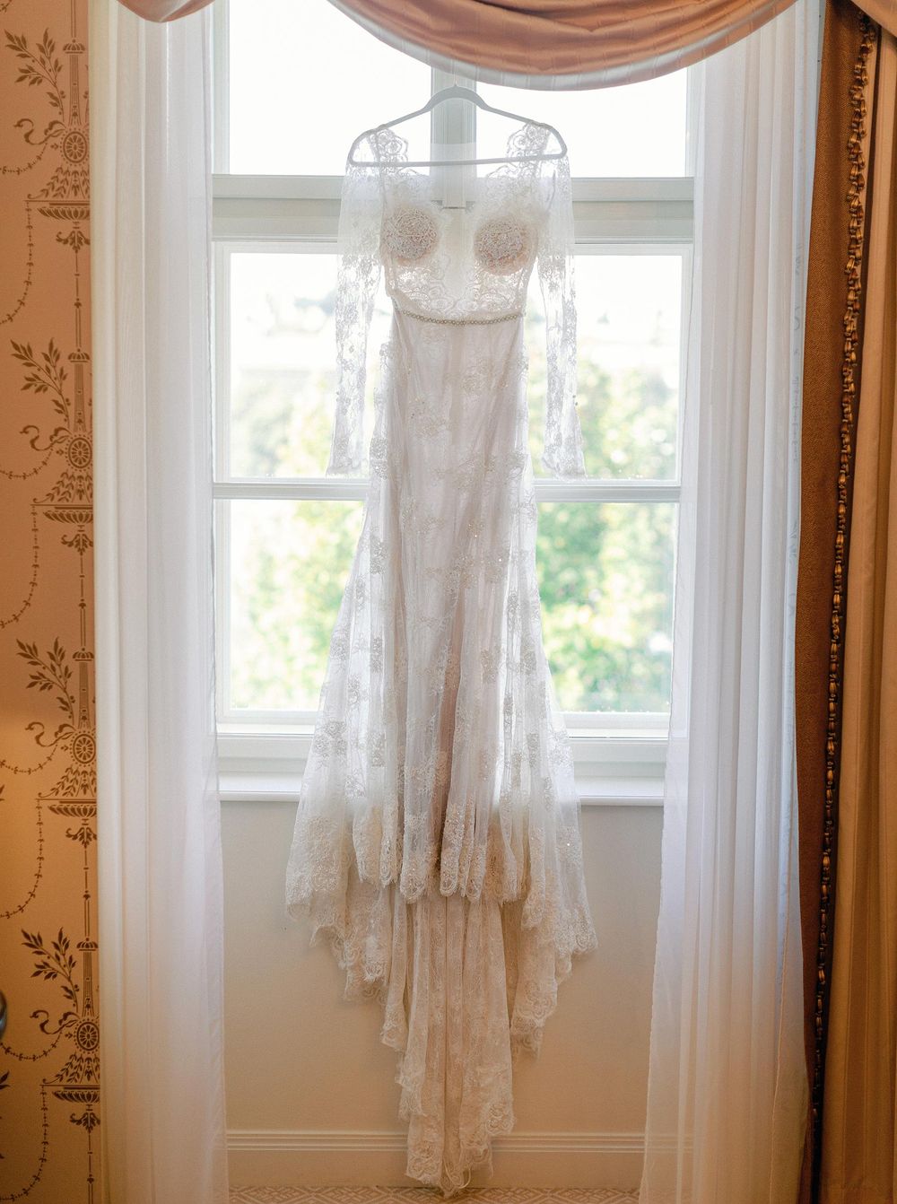 Elegant bridal gown displayed on a window.