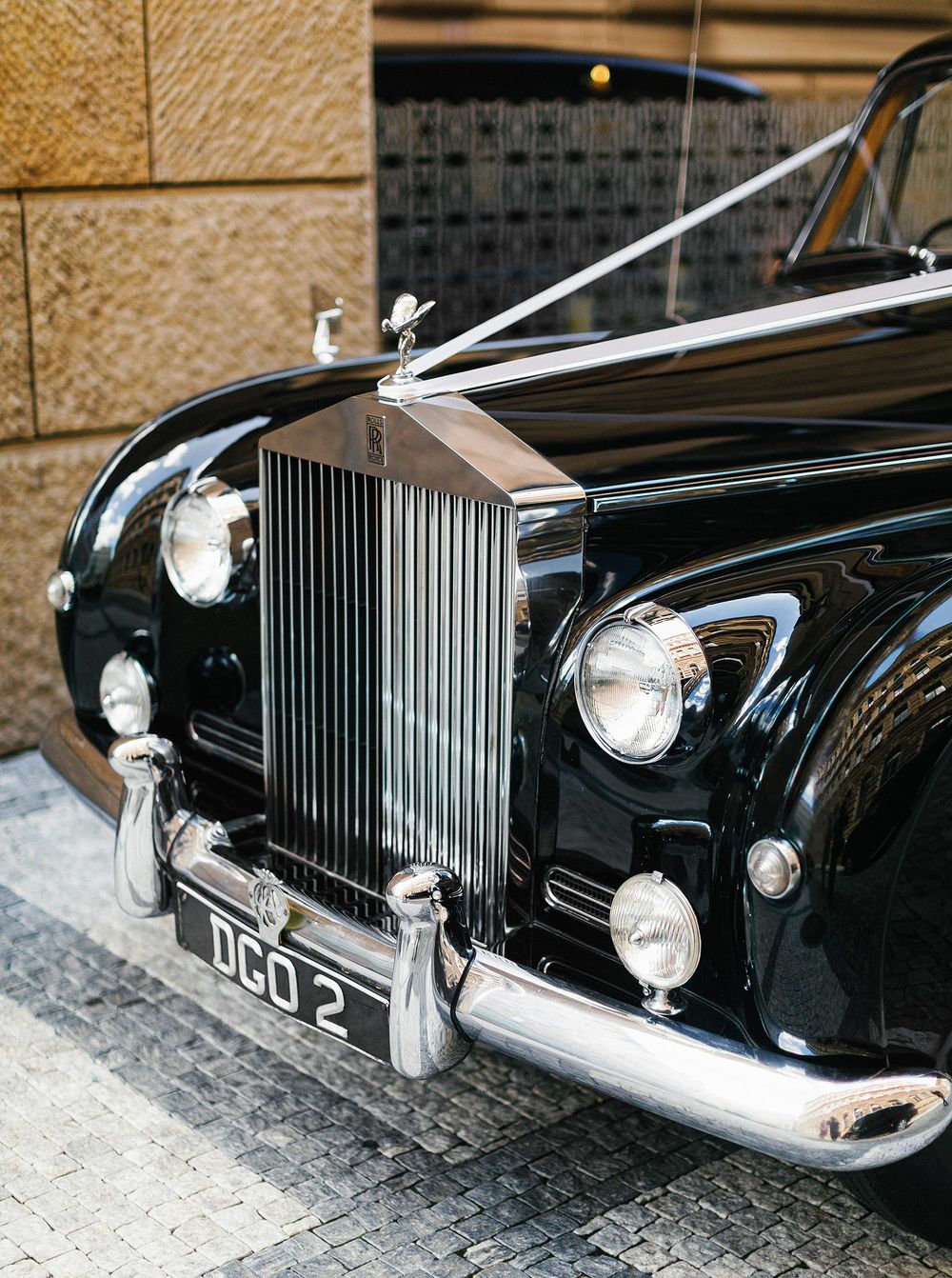 Elegant Rolls Royce with white stripe outside Four Seasons hotel in Prague.