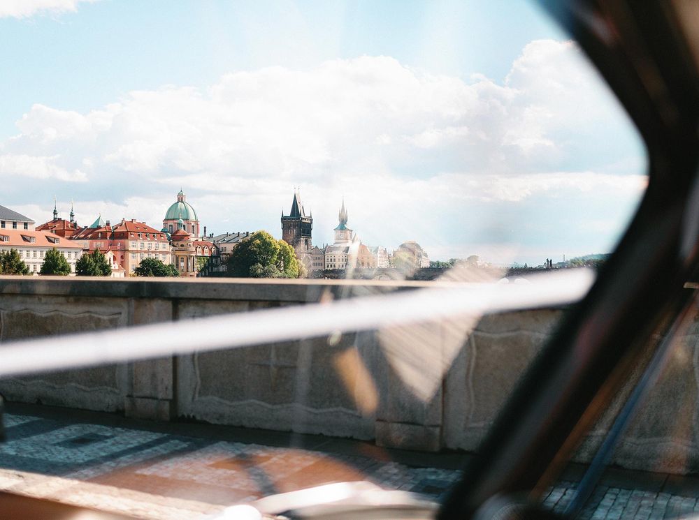 A cityscape of Prague seen through a car window, showcasing the urban beauty and charm in a single frame.