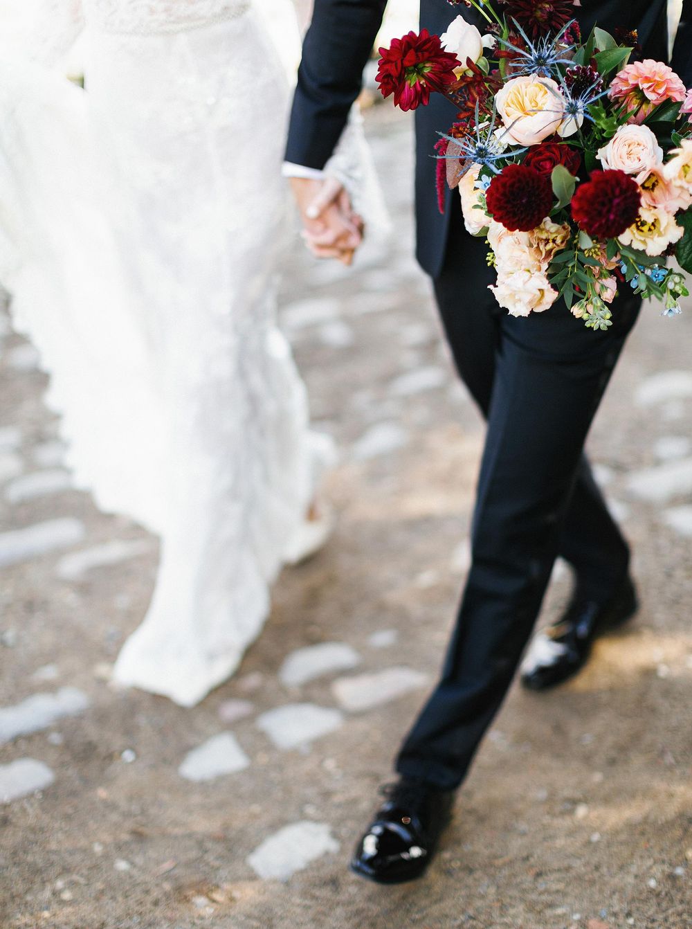 Newlyweds strolling down a path hand in hand.