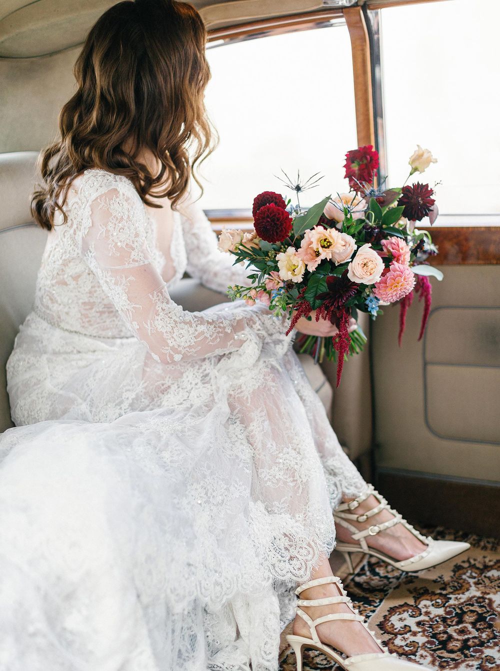 A luxurious bride sitting in a Rolls Royce, ready to embark on her special day in Prague.