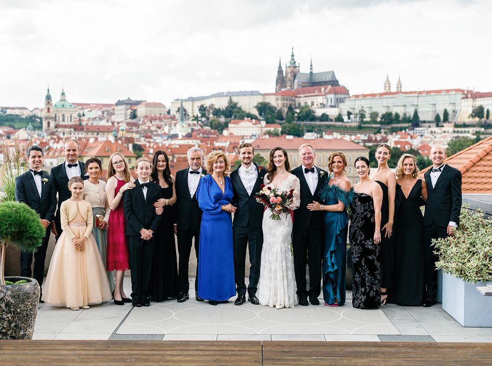 Wedding group photo at rooftop of Four Seasons hotel with Prague castle backdrop.