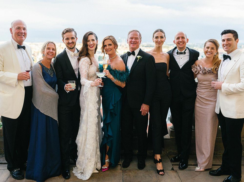 A wedding party in Prague, a group of people in formal attire posing for a photo.