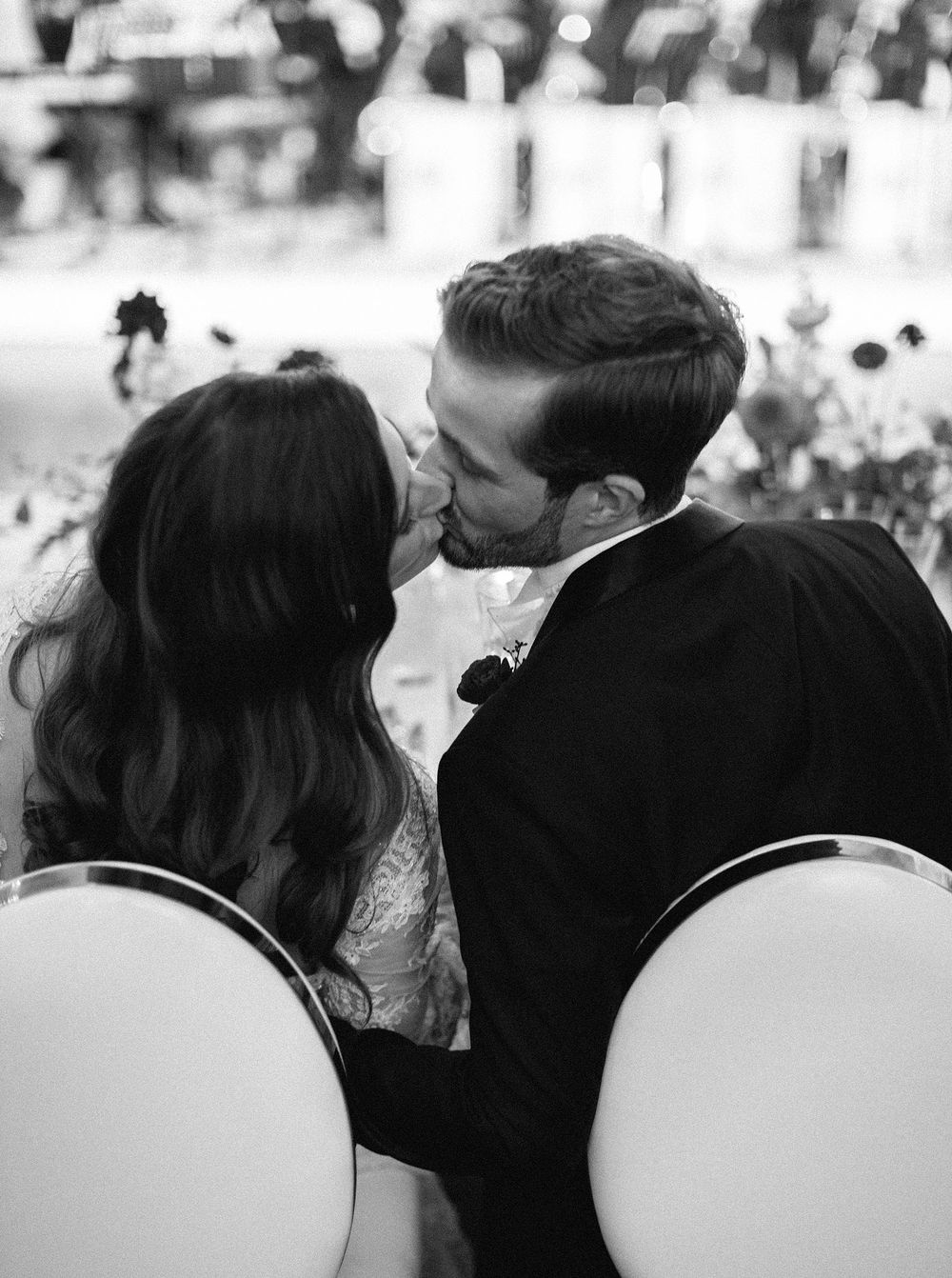 A bride and groom share a romantic kiss in front of a wedding orchestra at their reception in Lobkowicz palace, Prague.