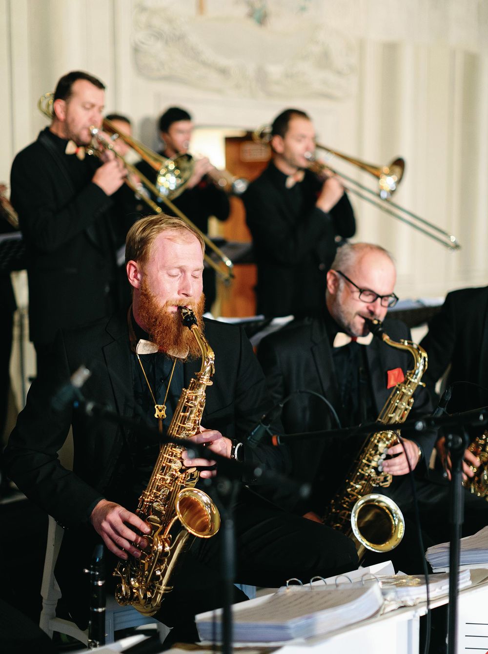A group of men in suits playing saxophones, creating a harmonious melody with their instruments.