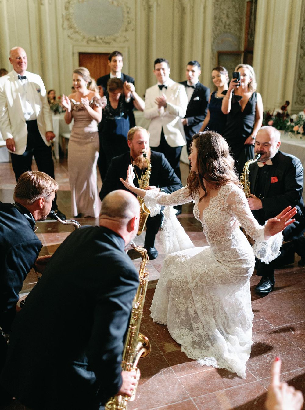 A bride joyfully dance with their guests at their wedding in Lobkowicz Palace, Prague.