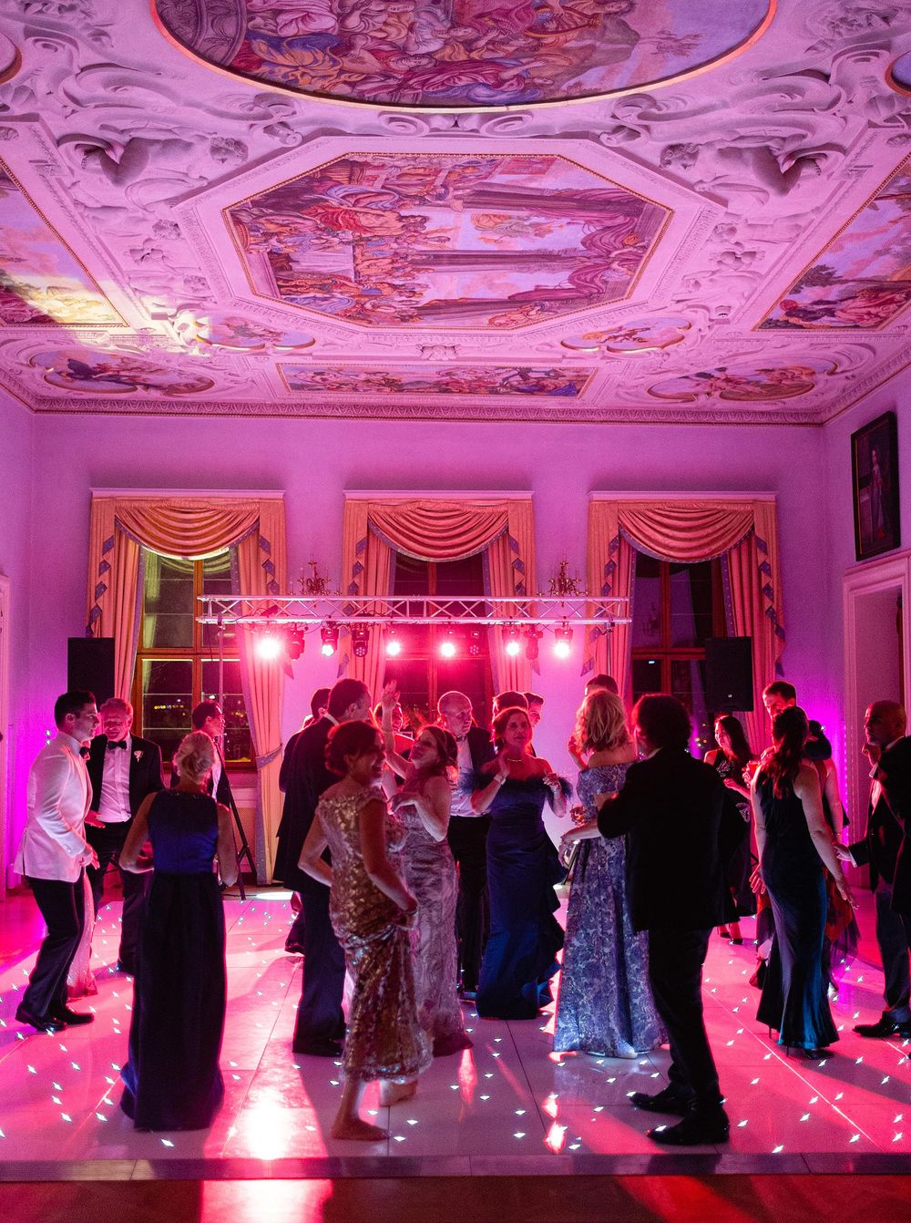 Wedding dance party at Lobkowicz Palace, Prague: Guests dancing joyfully in a grand ballroom.
