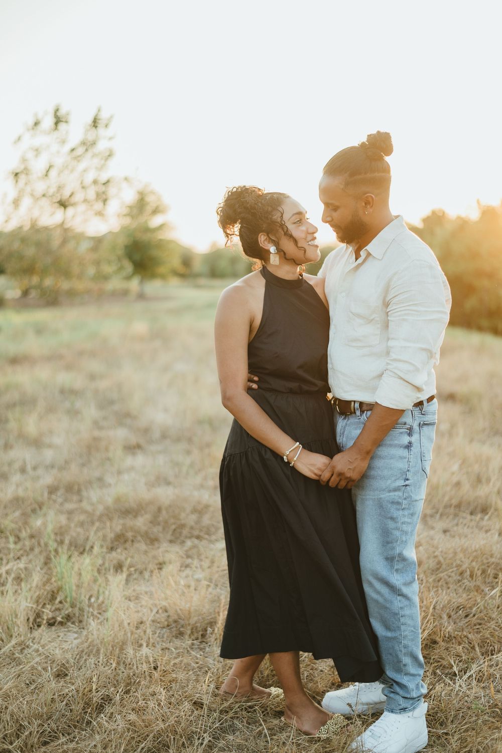 Couple in coordinated outfits sharing an intimate moment in golden hour lighting.