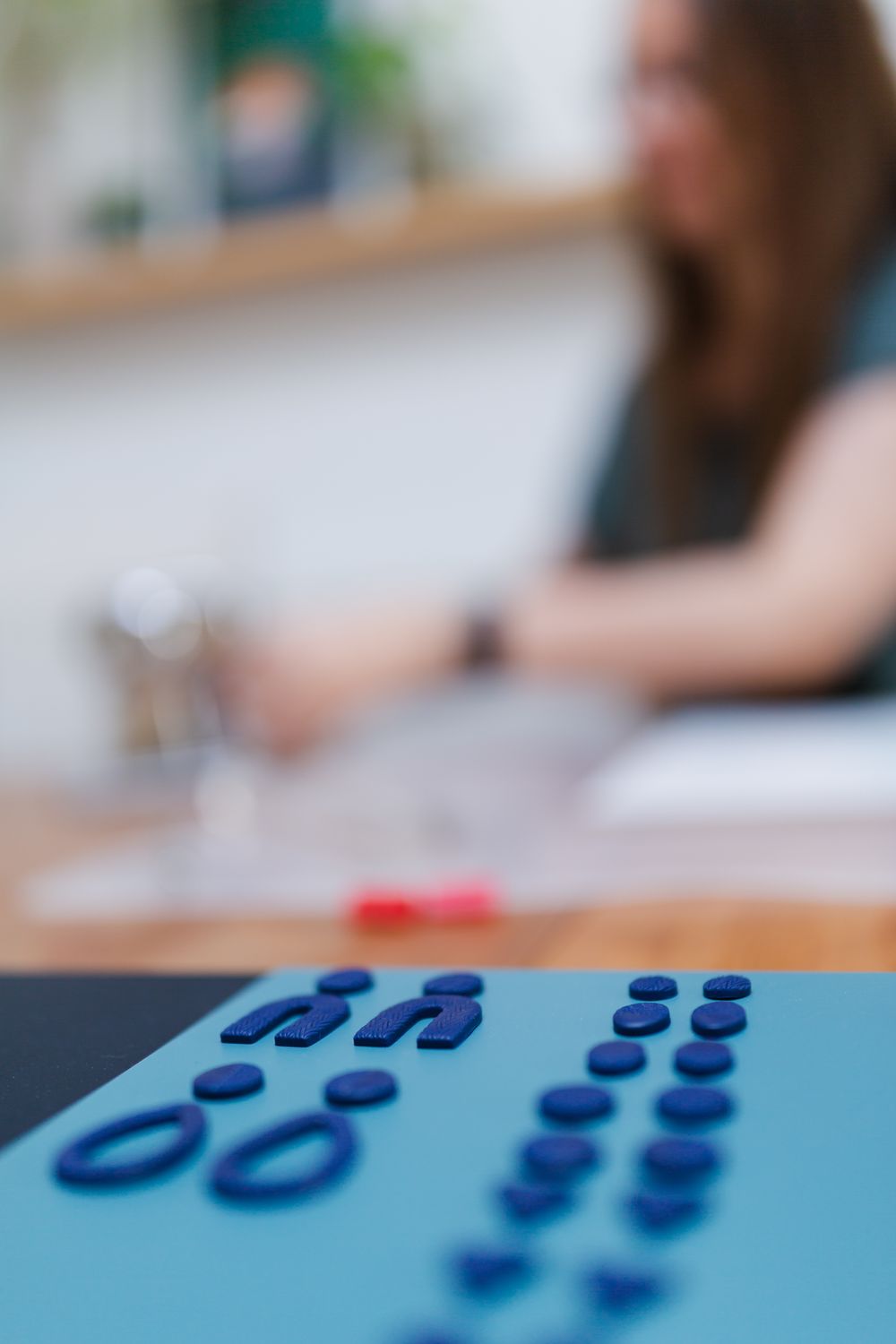 Close-up of blue beads arranged on a light blue surface with artistic patterns.