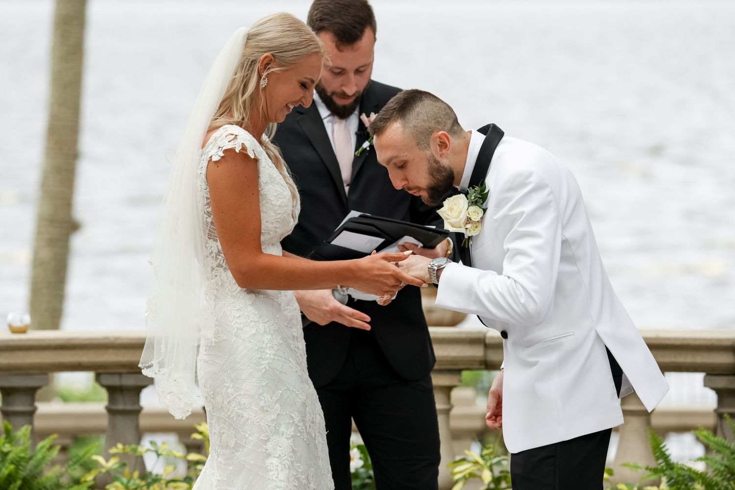 Emotional moment shared during wedding ceremony with three people in formal attire.