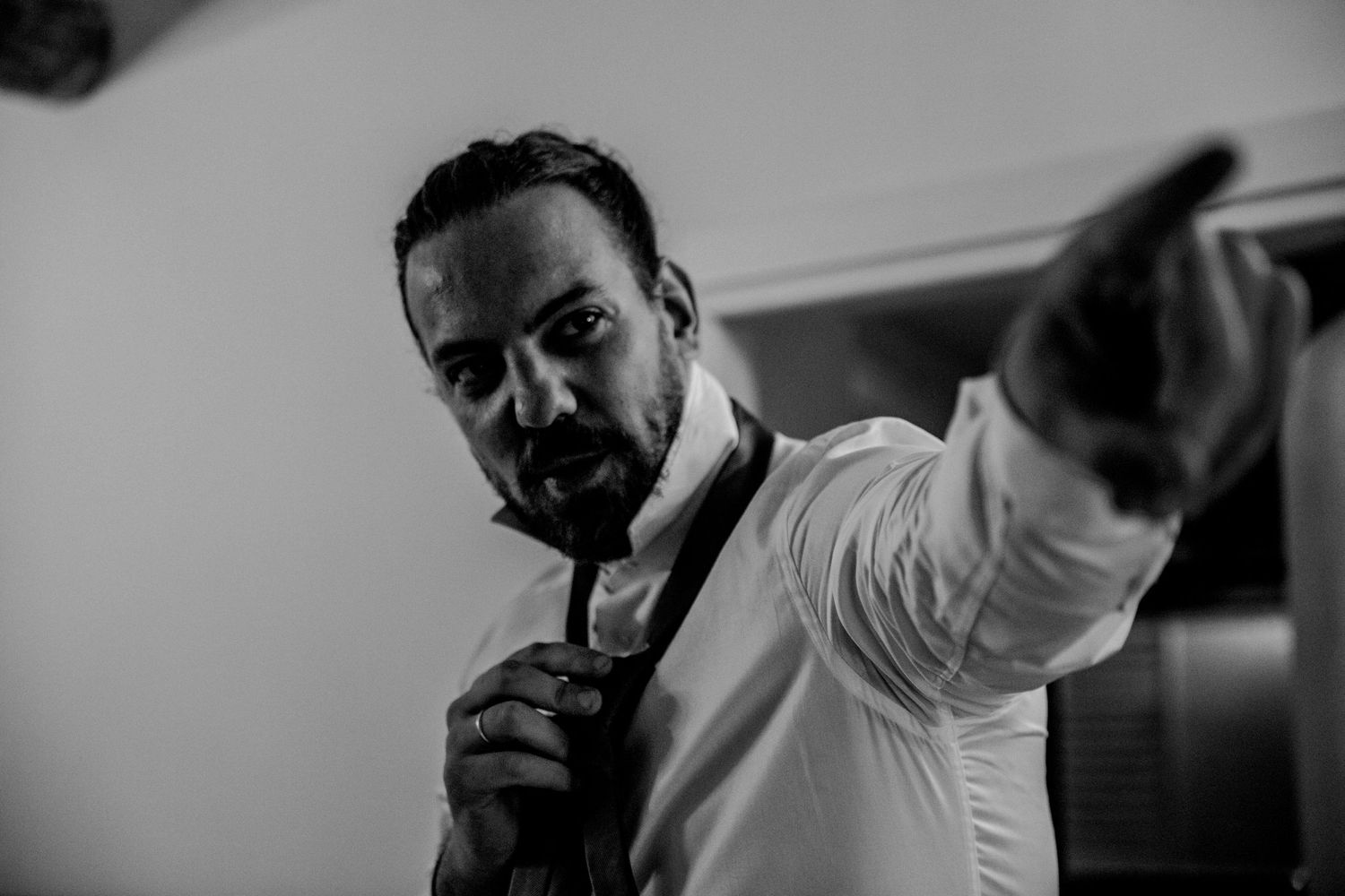 Dramatic black and white shot of someone in formal attire striking a confident pose.