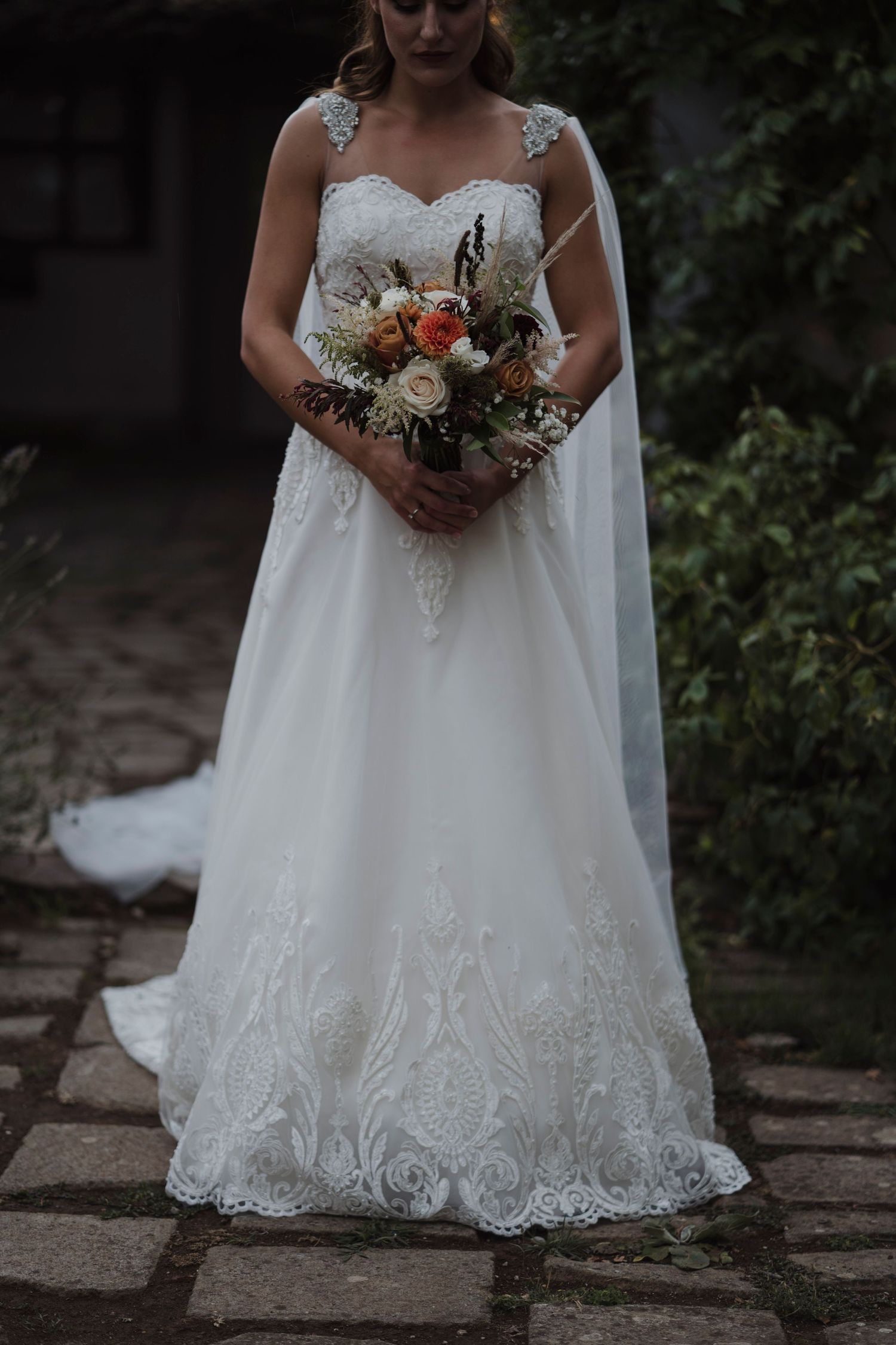 Close up of bridal bouquet with white lace wedding dress details.