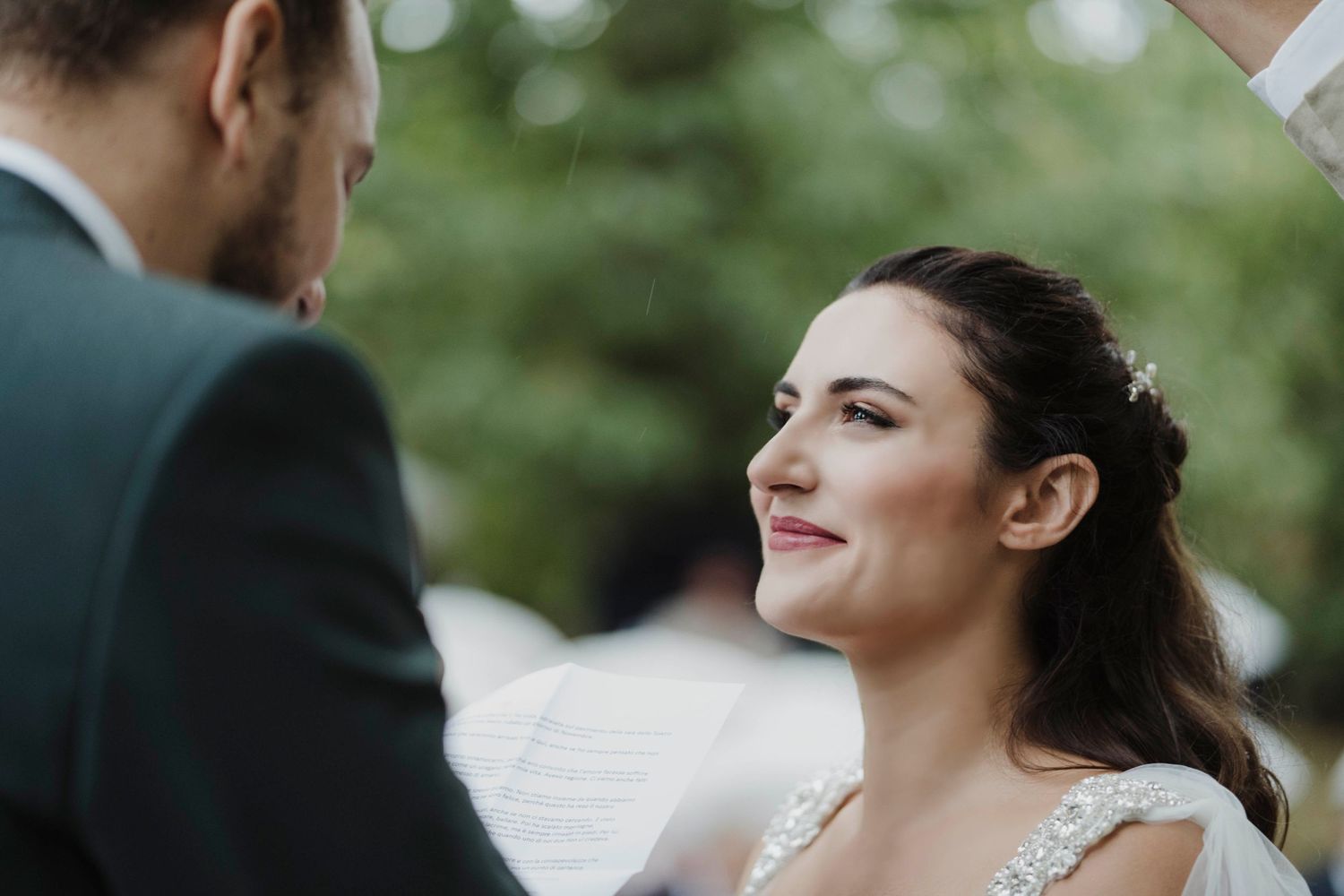 Intimate moment during outdoor wedding ceremony with natural lighting.