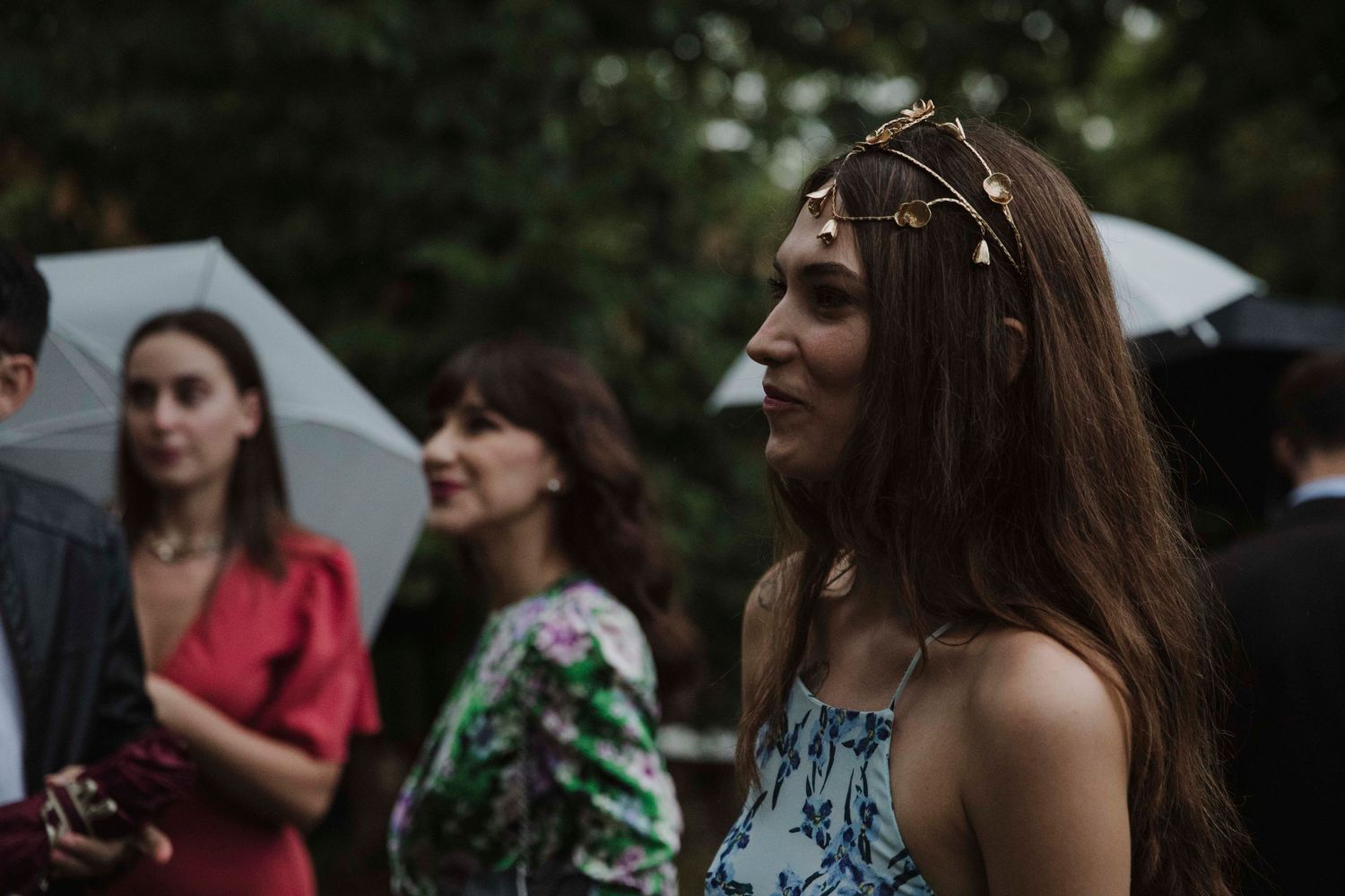 A guest at an outdoor celebration wearing a delicate floral headpiece.