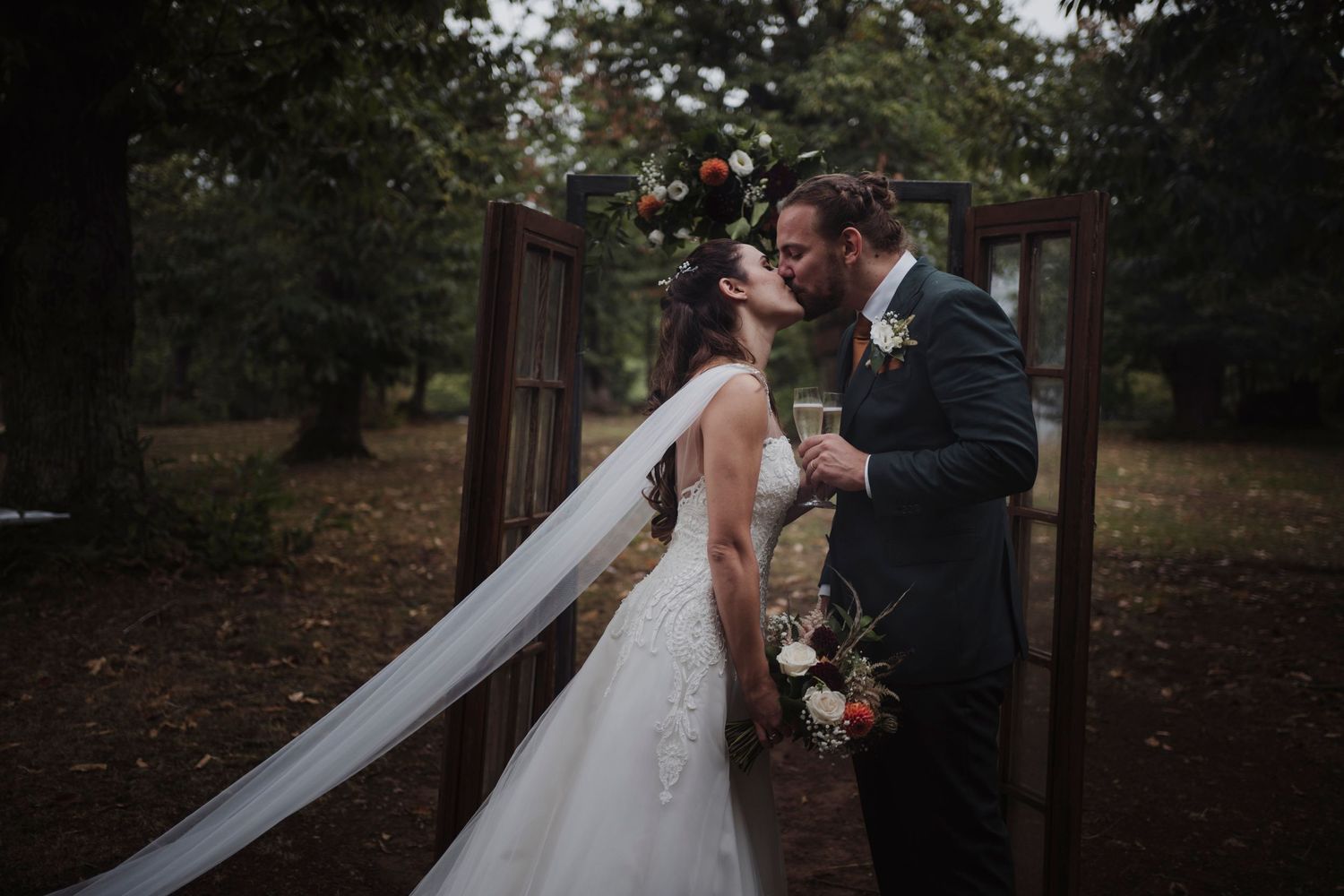A dreamy wedding scene with a flowing veil and rustic wooden door backdrop.
