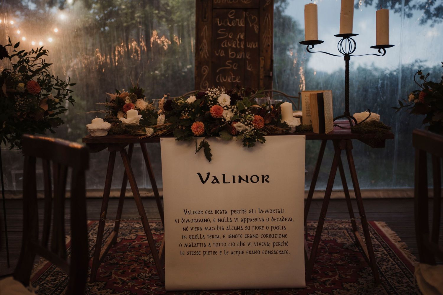 Romantic ceremony setup with Valimor signage, candlesticks and floral arrangements at dusk.
