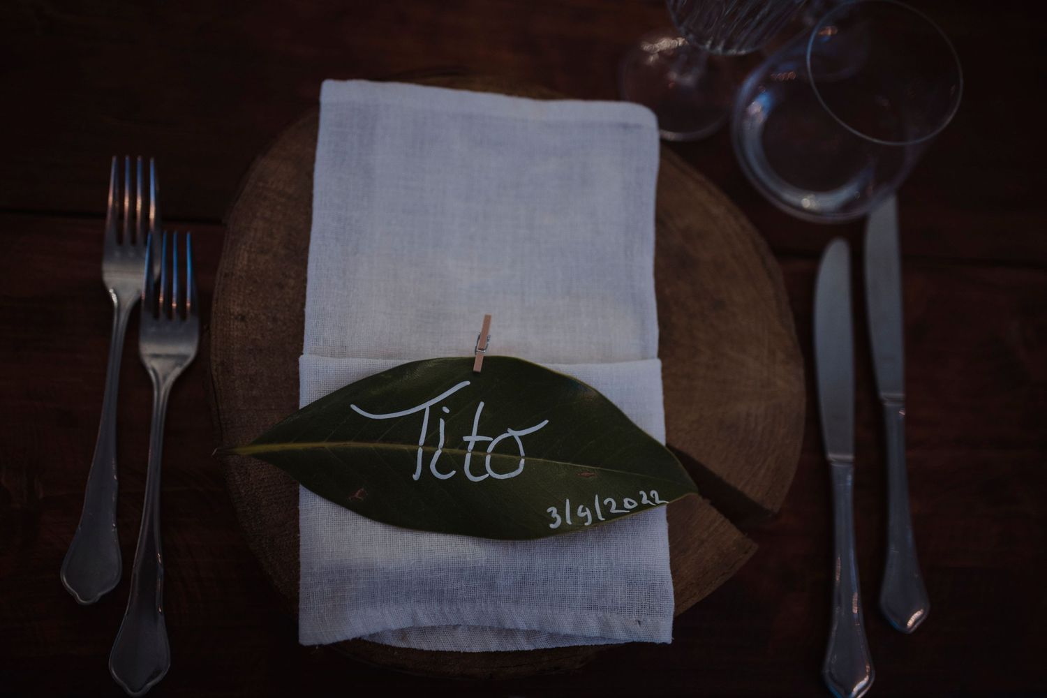 Place setting with white napkin and green leaf name card reading Pete.