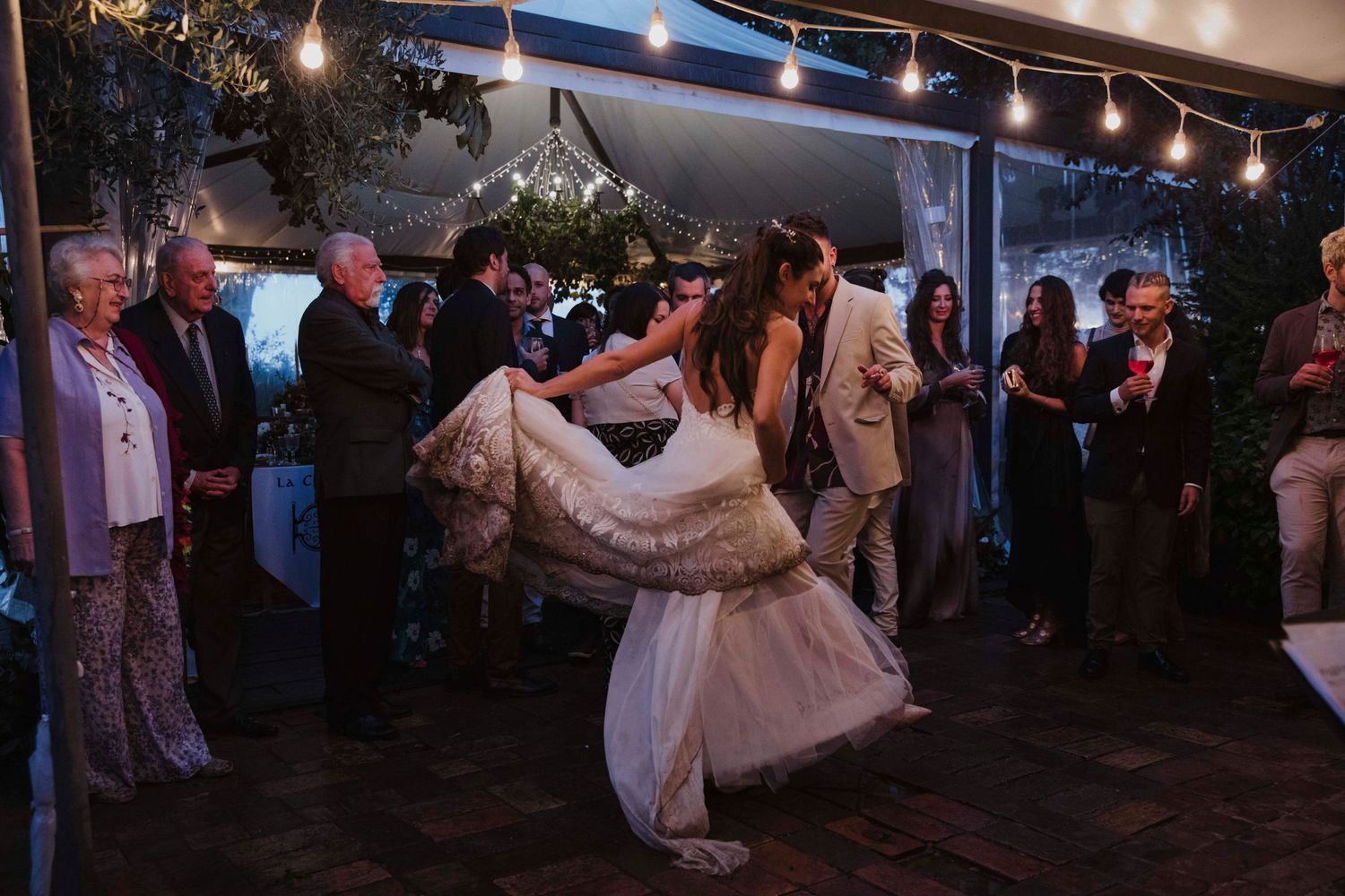 Dancers twirling in elegant wedding attire during an evening reception.