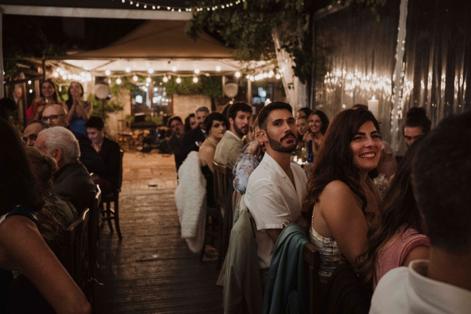 Lively reception scene with guests dancing and celebrating under ambient lighting.