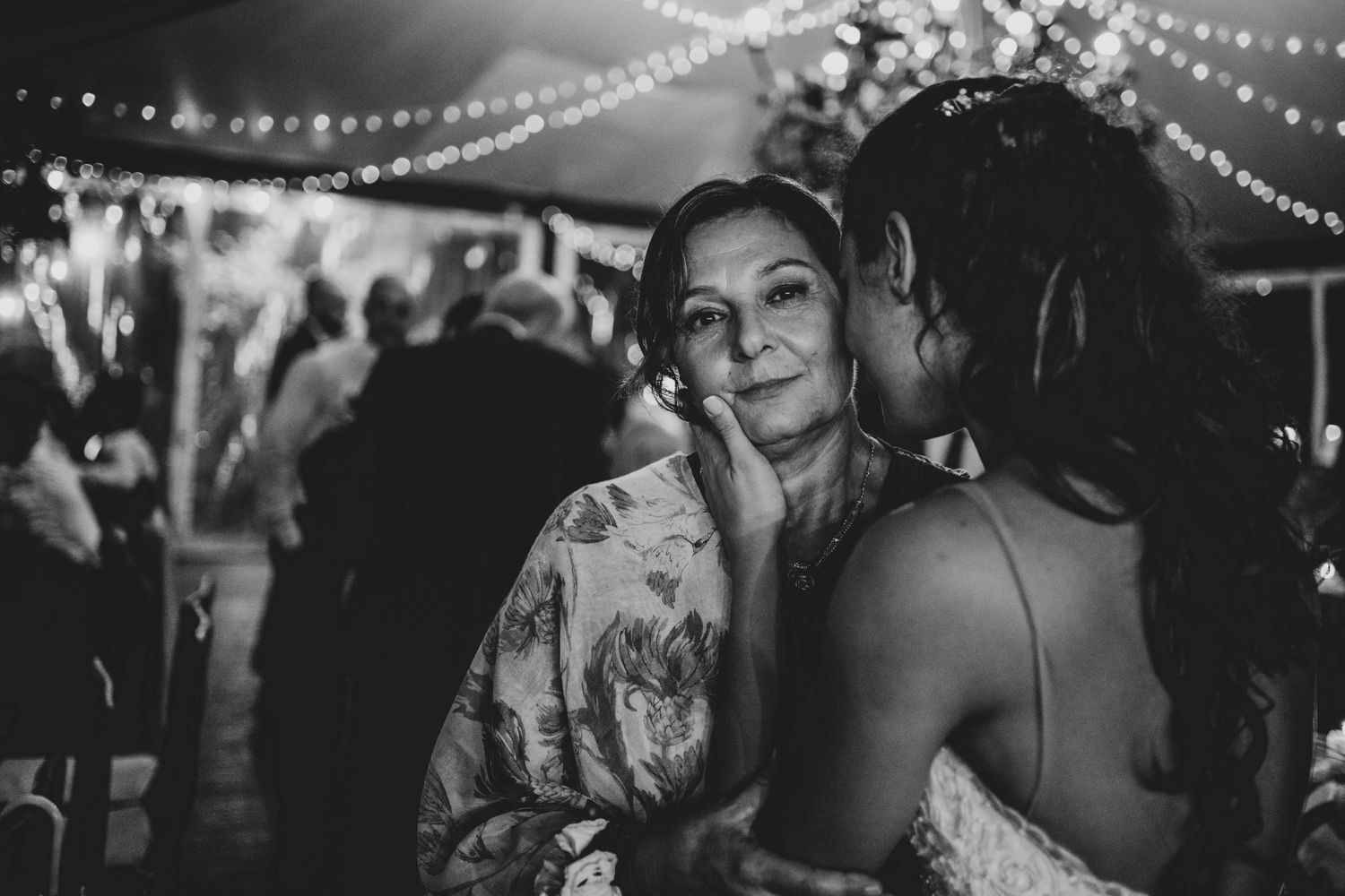 Wedding reception dance floor moment captured under twinkling string lights.