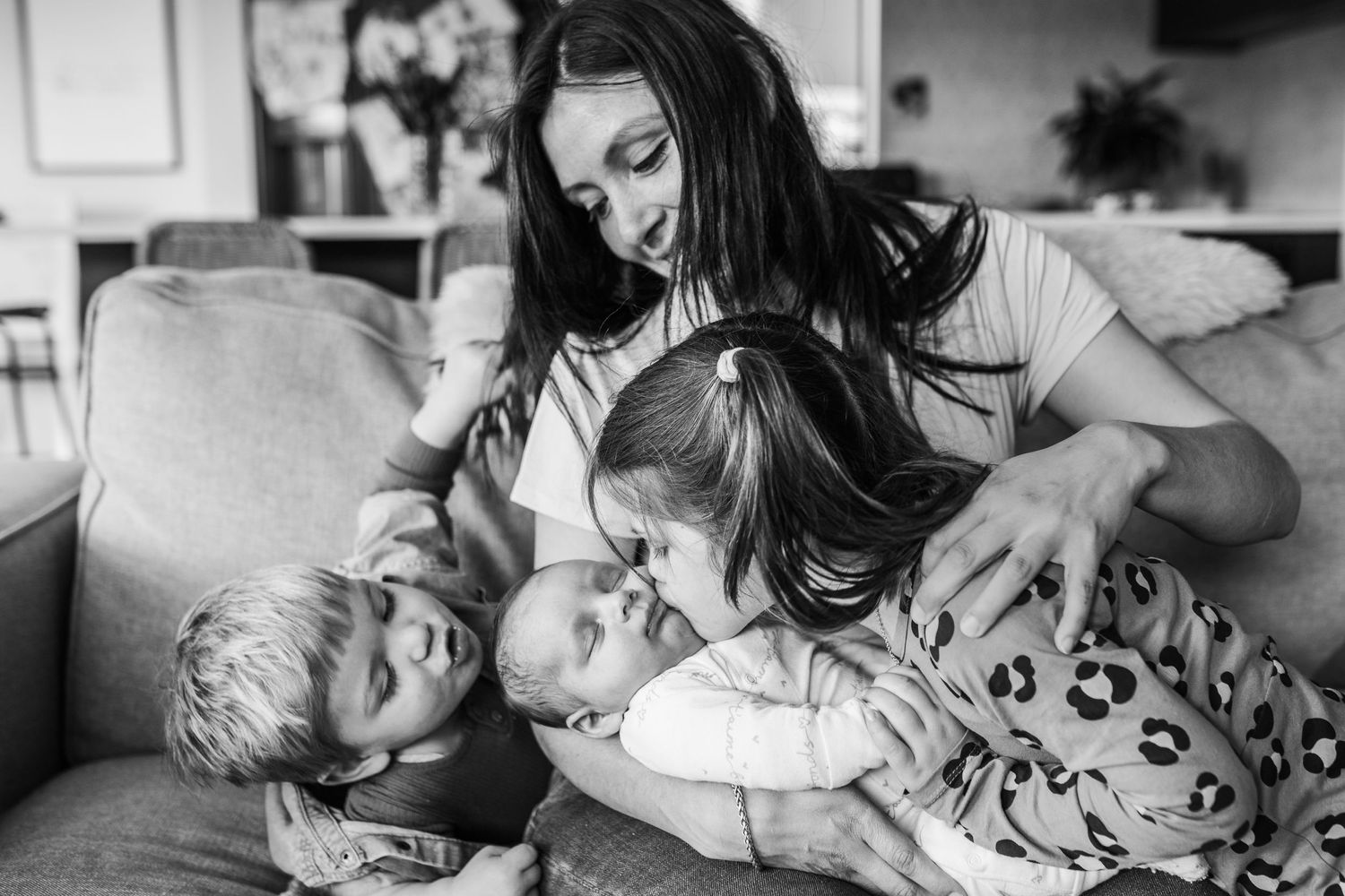 A heartwarming family moment captured in black and white on a couch.